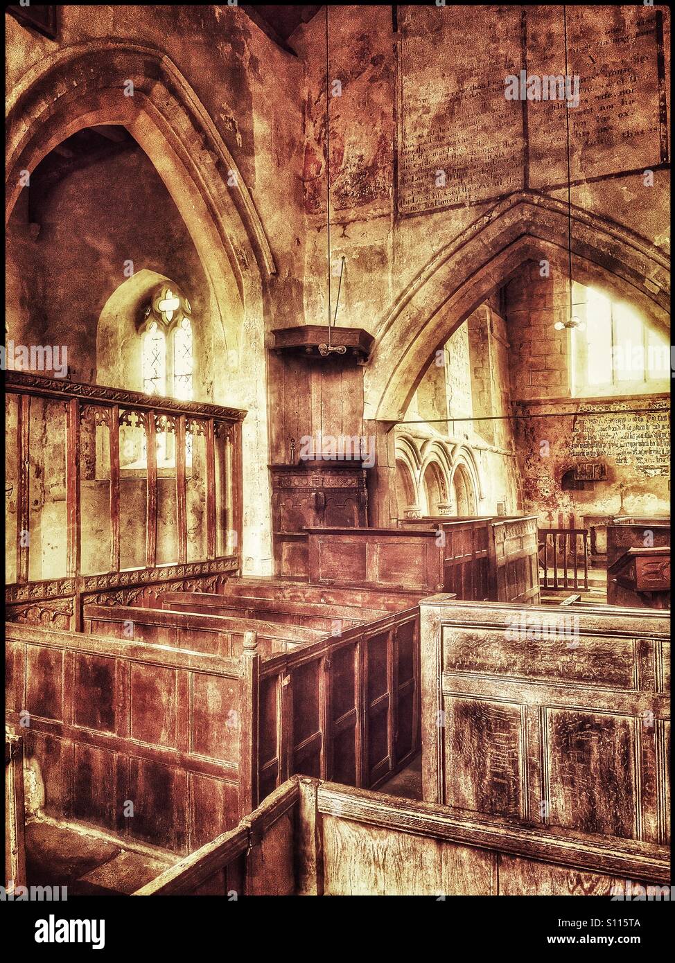 Un effetto di grunge immagine dell'interno della chiesa ridondante di San Giovanni Battista in Inglesham, Wiltshire, Inghilterra, Regno Unito. Chiaramente visibile è il 1630 pulpito giacobino & il Carolean-casella stile banchi. Foto Stock