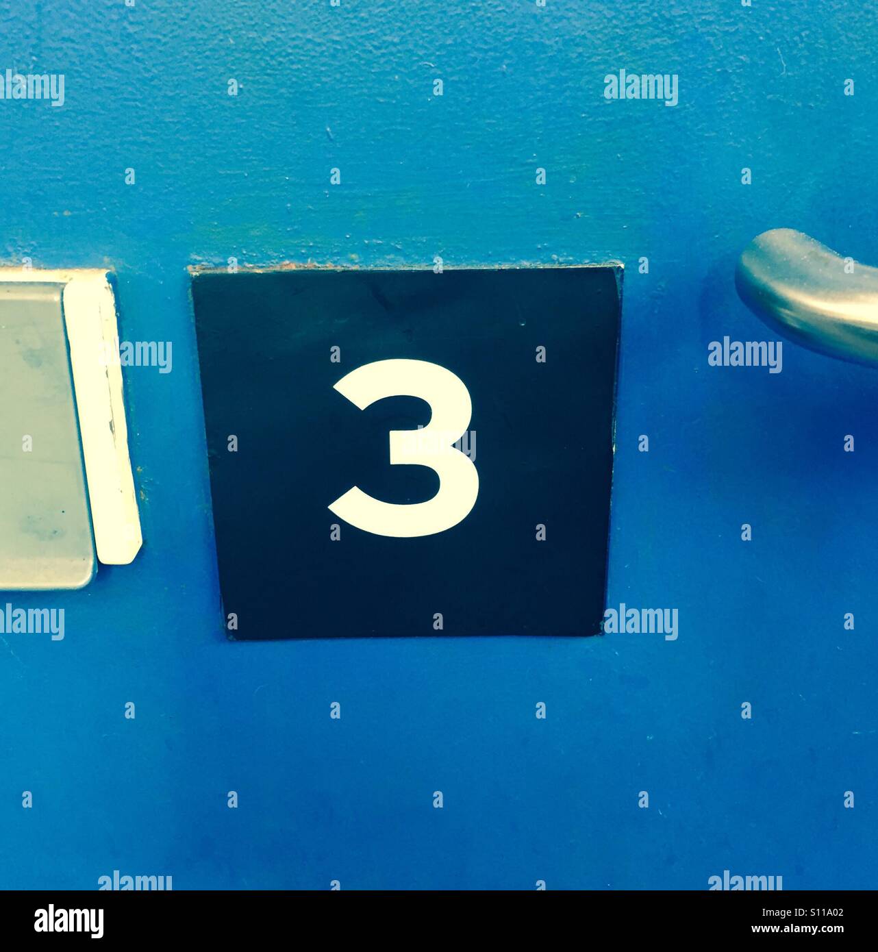 Un numero 3 su una porta d'ingresso - Immagine stock catturata con smartphone