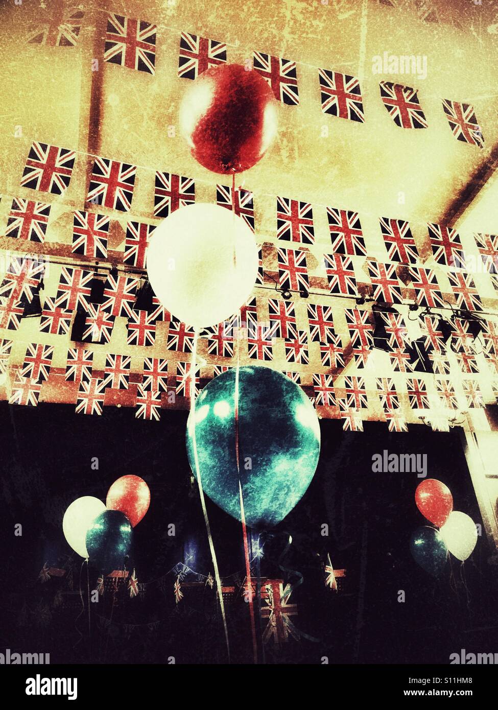 Una sala decorata con Union Jack Flag come bunting, plus rosso, bianco e blu palloncini. In Inghilterra. - Immagine stock catturata con smartphone