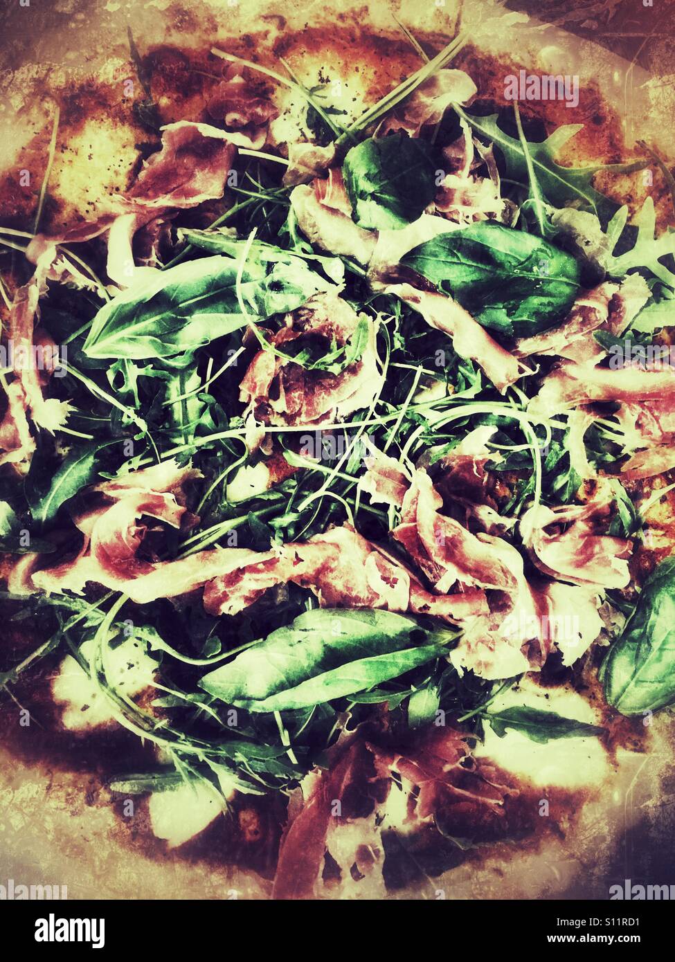 La pizza fatta in casa. Il prosciutto di Parma, rucola e basilico fresco. Foto Stock