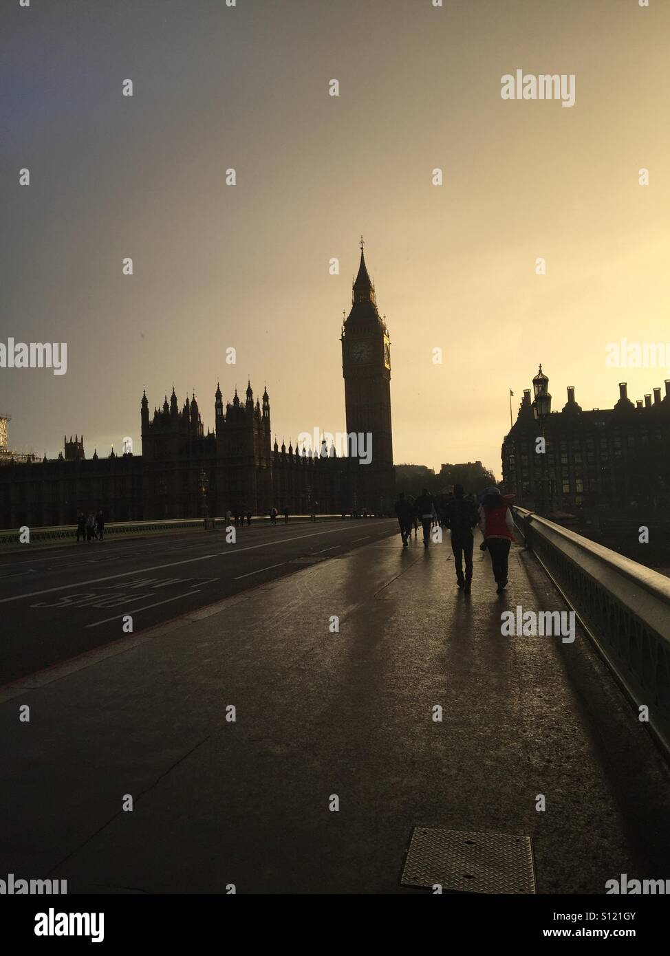 Persone che camminano giù Westminster Bridge sotto la pioggia Foto Stock