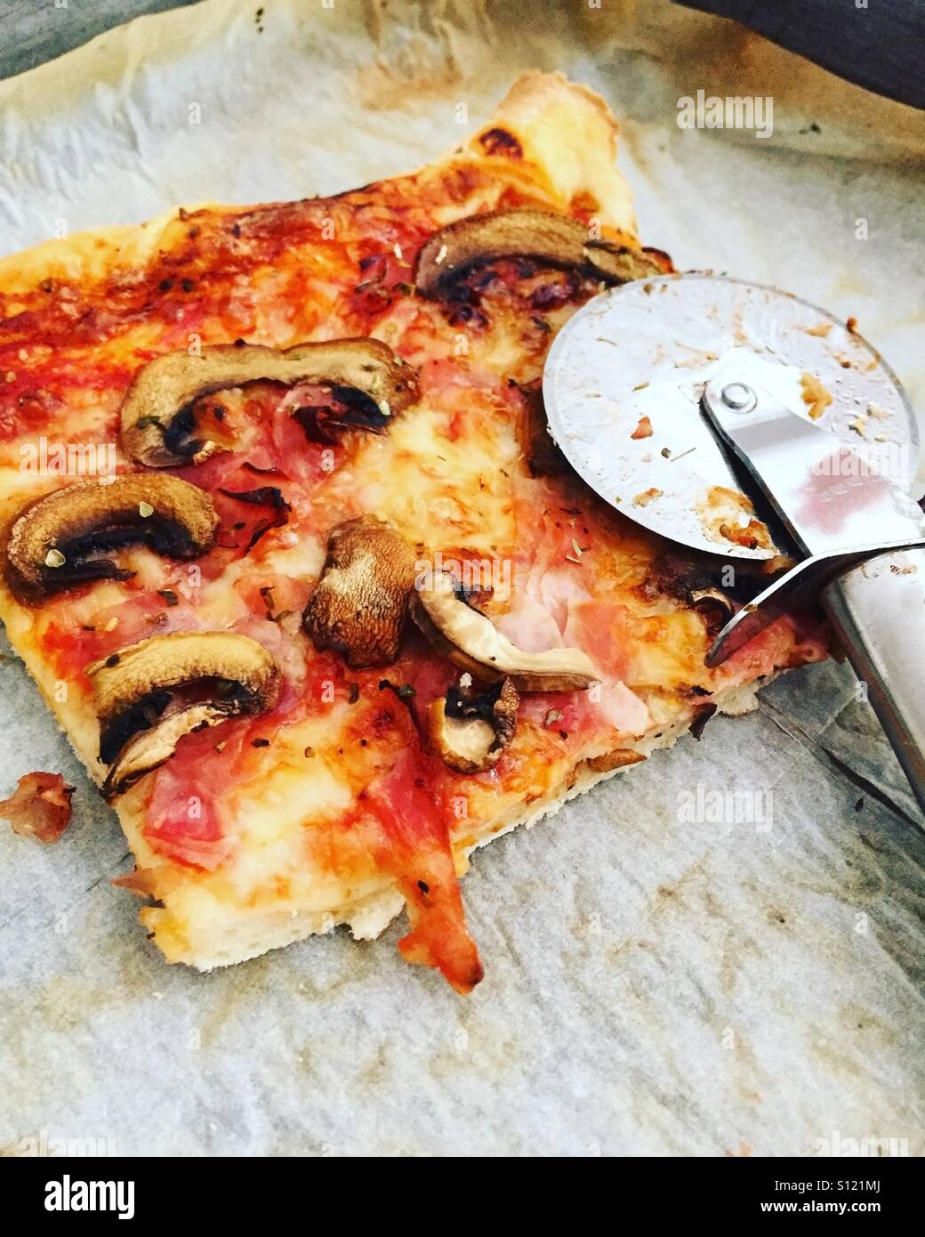 Fetta di fatto in casa pizza con taglierina Foto Stock