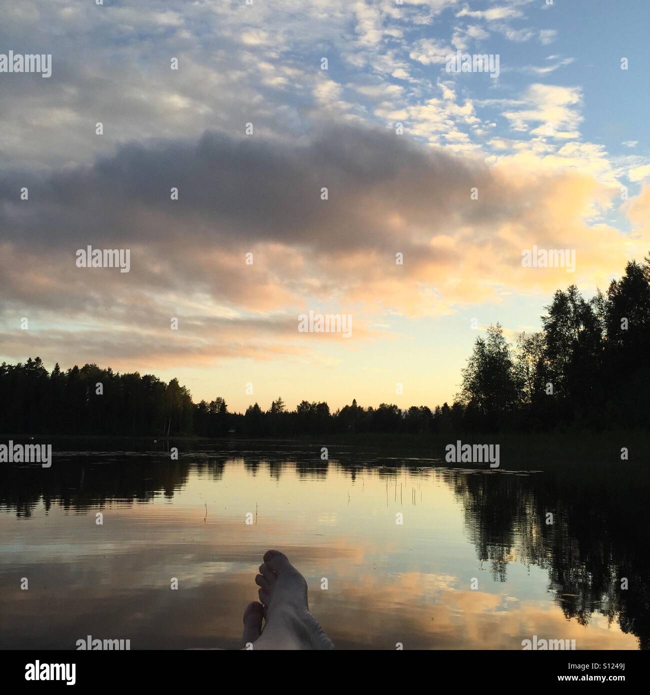 Godersi il tramonto da un lago in Finlandia Foto Stock