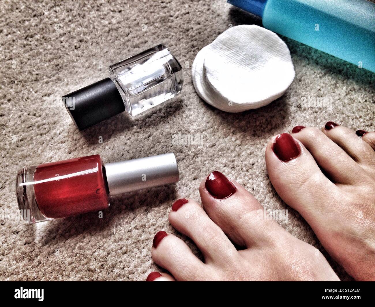 Red pedicure e smalti per unghie su un pavimento Foto Stock