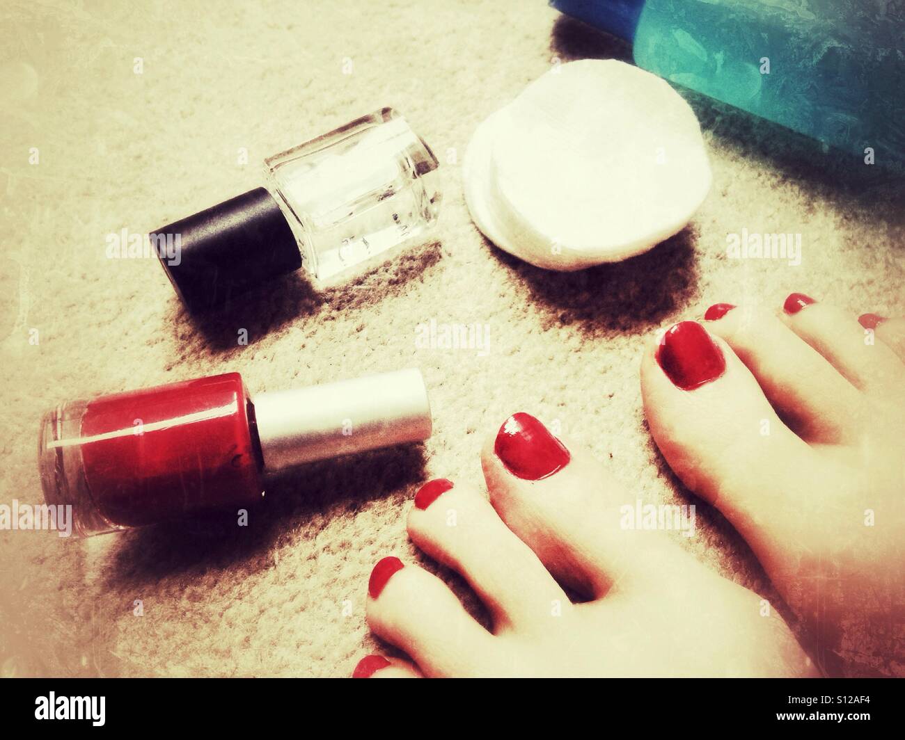 Red pedicure e smalti per unghie su un tappeto. Foto Stock