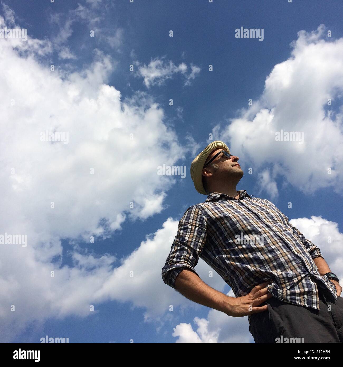 L uomo sta con il cielo blu e nuvole dietro a Londra Foto Stock