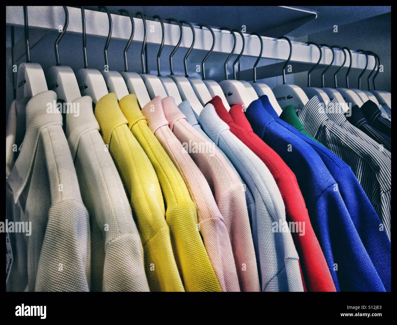 T-shirt polo su un appendiabiti in un negozio - Immagine stock catturata con smartphone