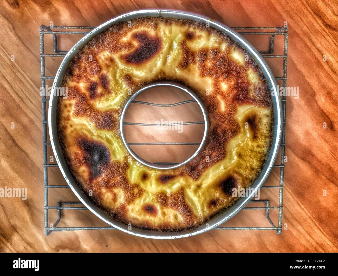 Un caramello crema pasticcera, cotte ancora nel suo stampo su un vassoio di raffreddamento - Immagine stock catturata con smartphone