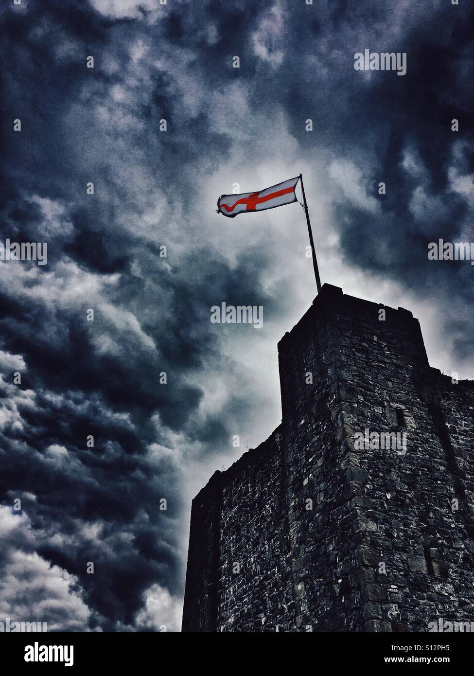 Clitheroe Castle mantenere e St Georges bandiera contro un cielo drammatico Foto Stock