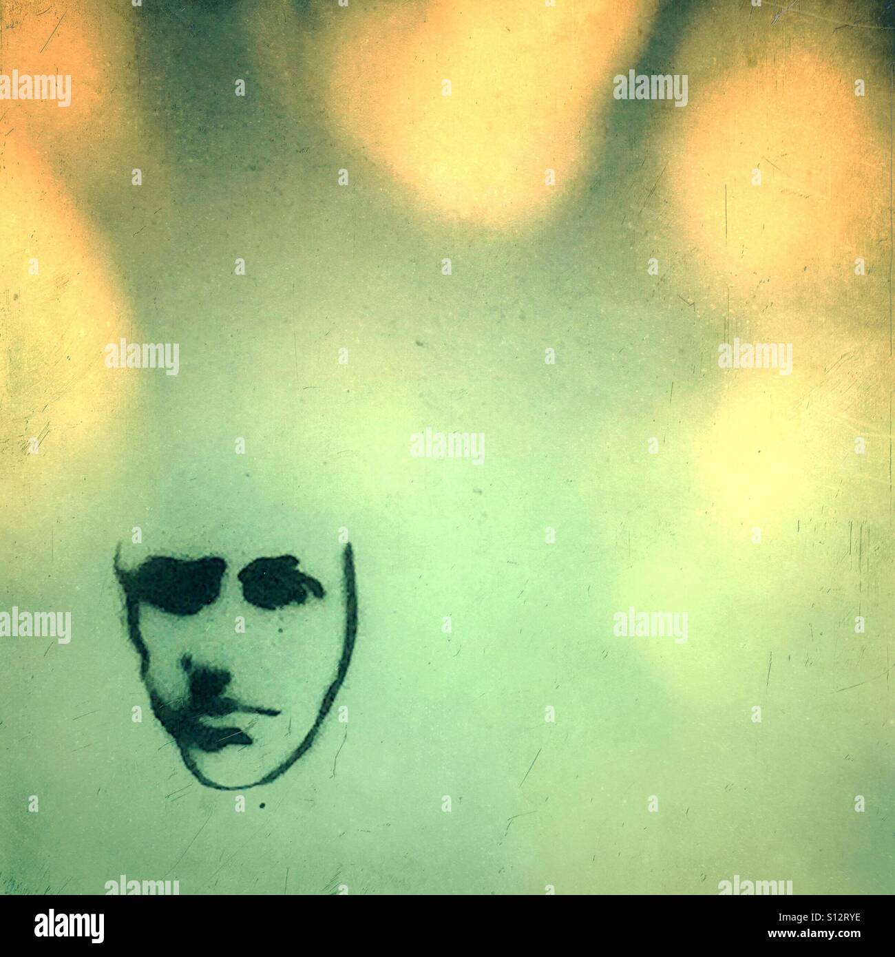 Faccina triste graffiti sul muro con ombra di un albero Foto Stock