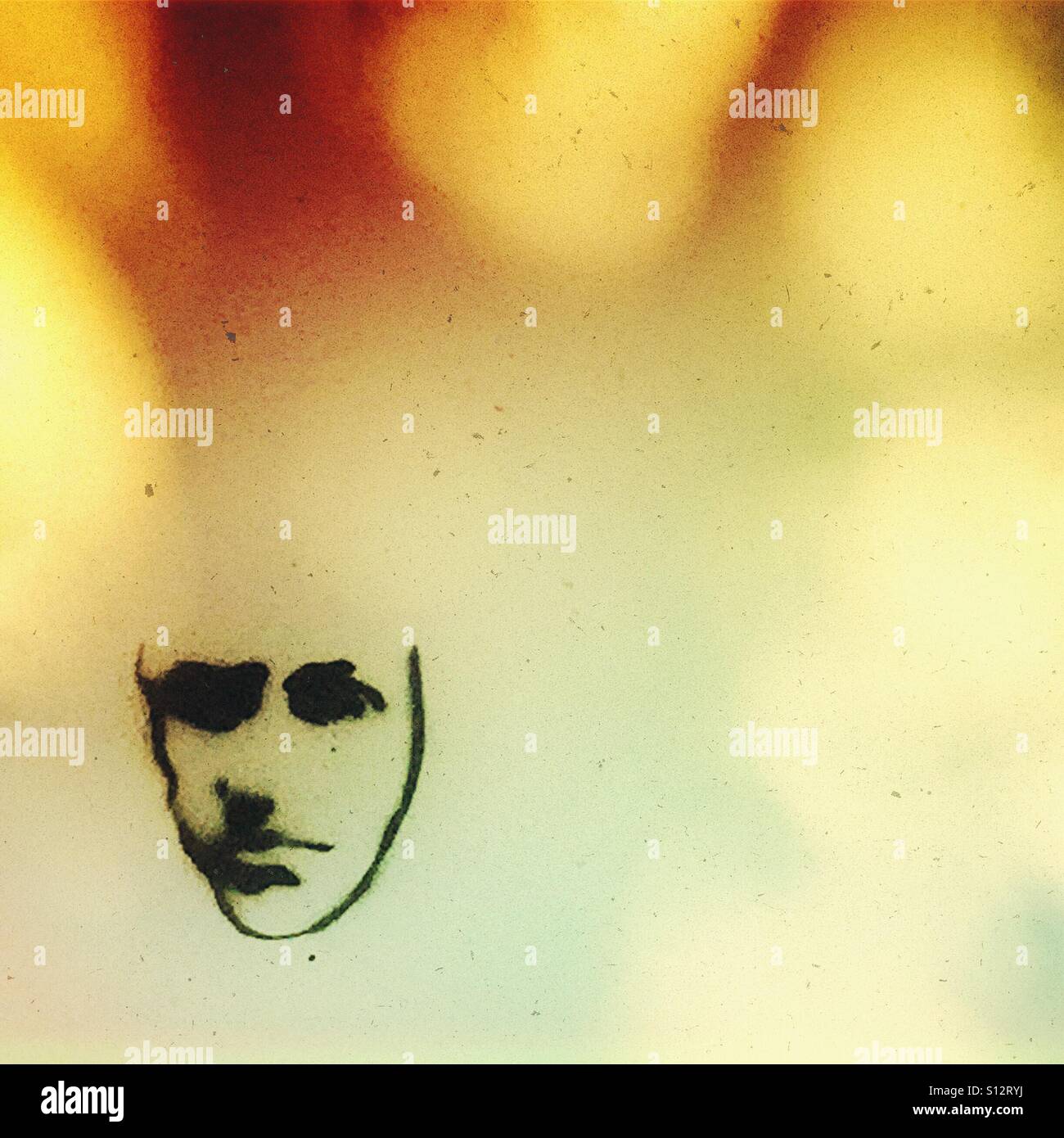 Il volto triste e graffiti su una parete con l'ombra di un albero Foto Stock