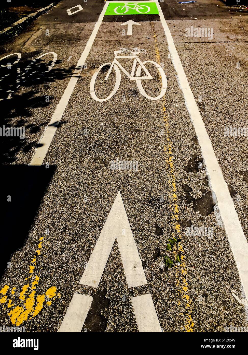 Verso le piste ciclabili. Dipinto di fresco. Ben segnalato. Segnaletica. Sentiero pavimentato. A due vie. Verde. Pittogramma. Nessuna gente. Contemporaneo. Foto Stock