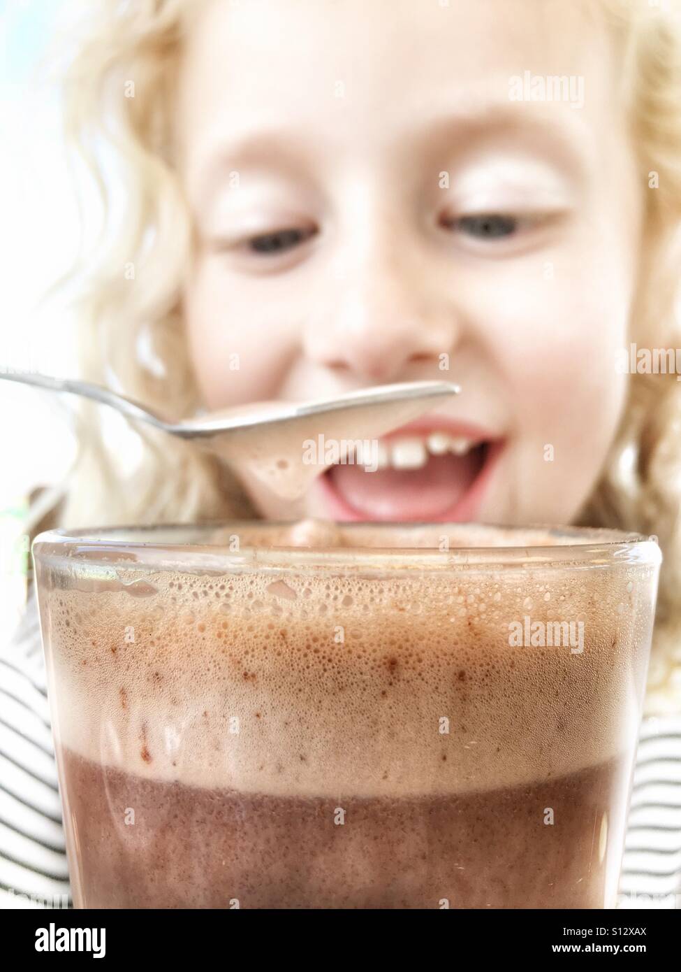 Ragazza giovane gustando un drink di cioccolato caldo Foto Stock