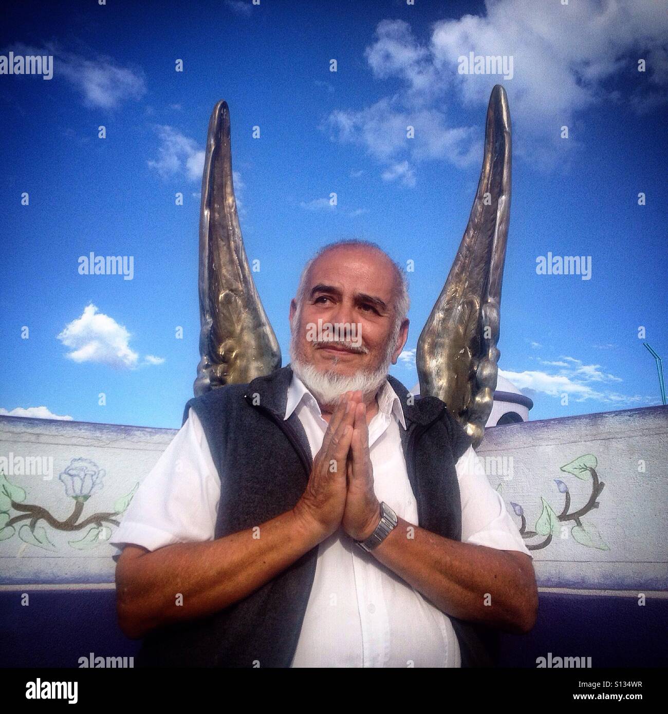 Il proprietario su Azucarillos de Antaño candy shop pone pregando davanti ad una coppia di ali a Peña de Bernal, Queretaro, Messico - Immagine stock catturata con smartphone