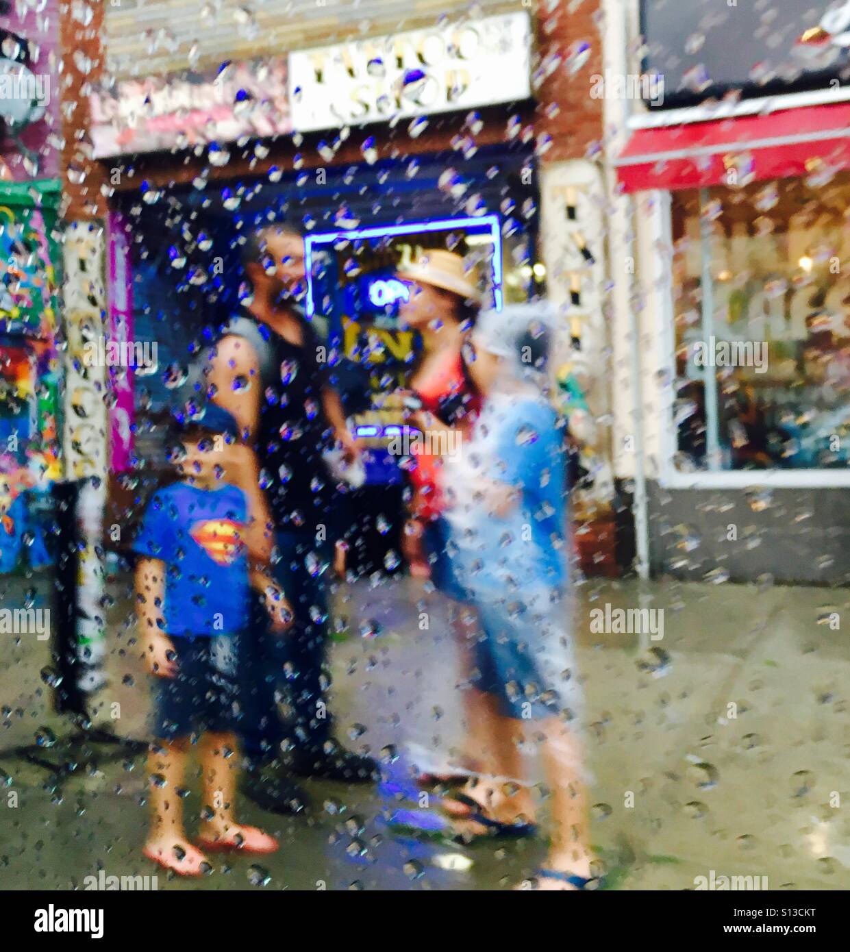 Famiglia sotto la pioggia Foto Stock