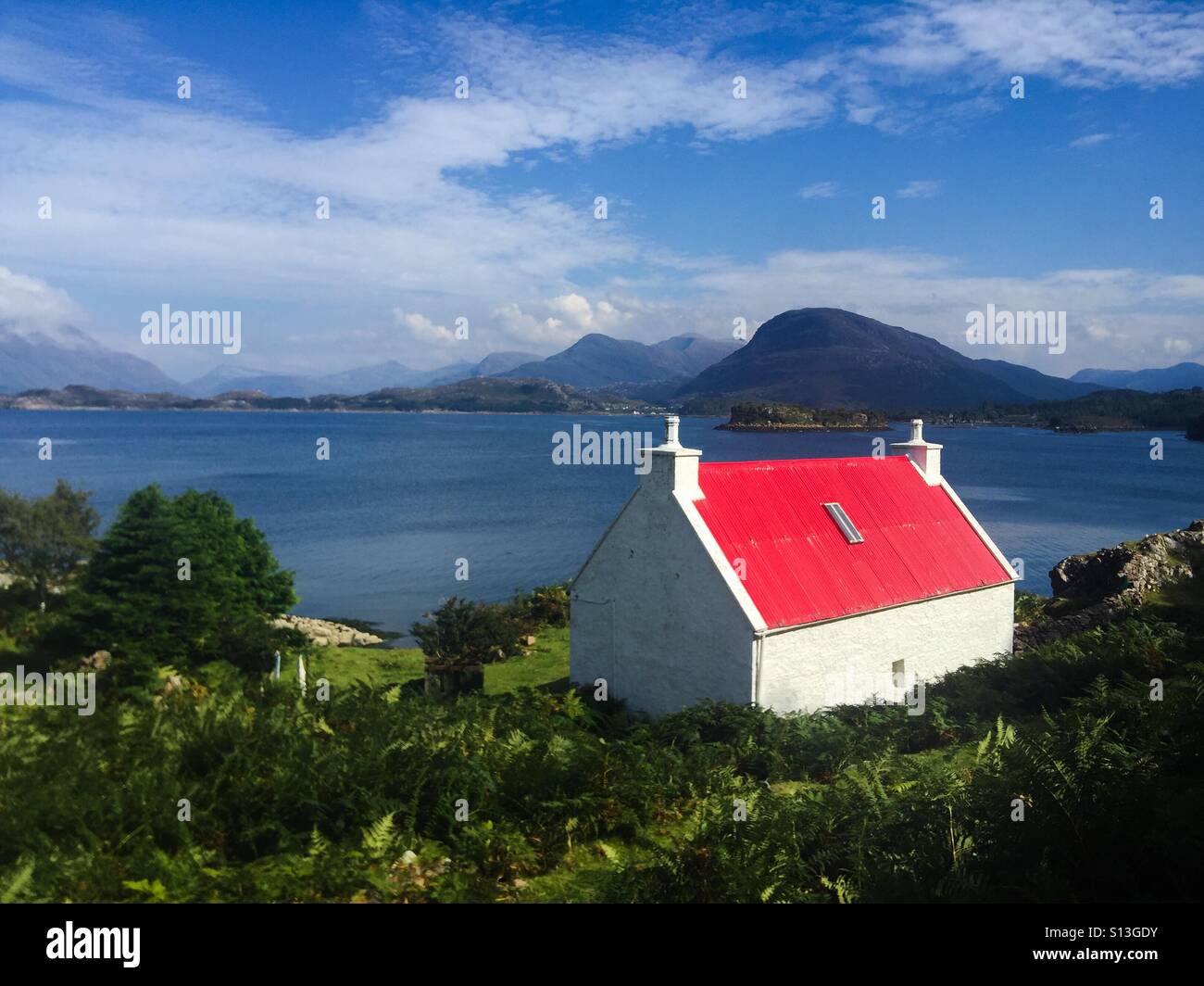 Rosso cottage con tetto in Torridon regione West Highlands della Scozia, Regno Unito - Immagine stock catturata con smartphone
