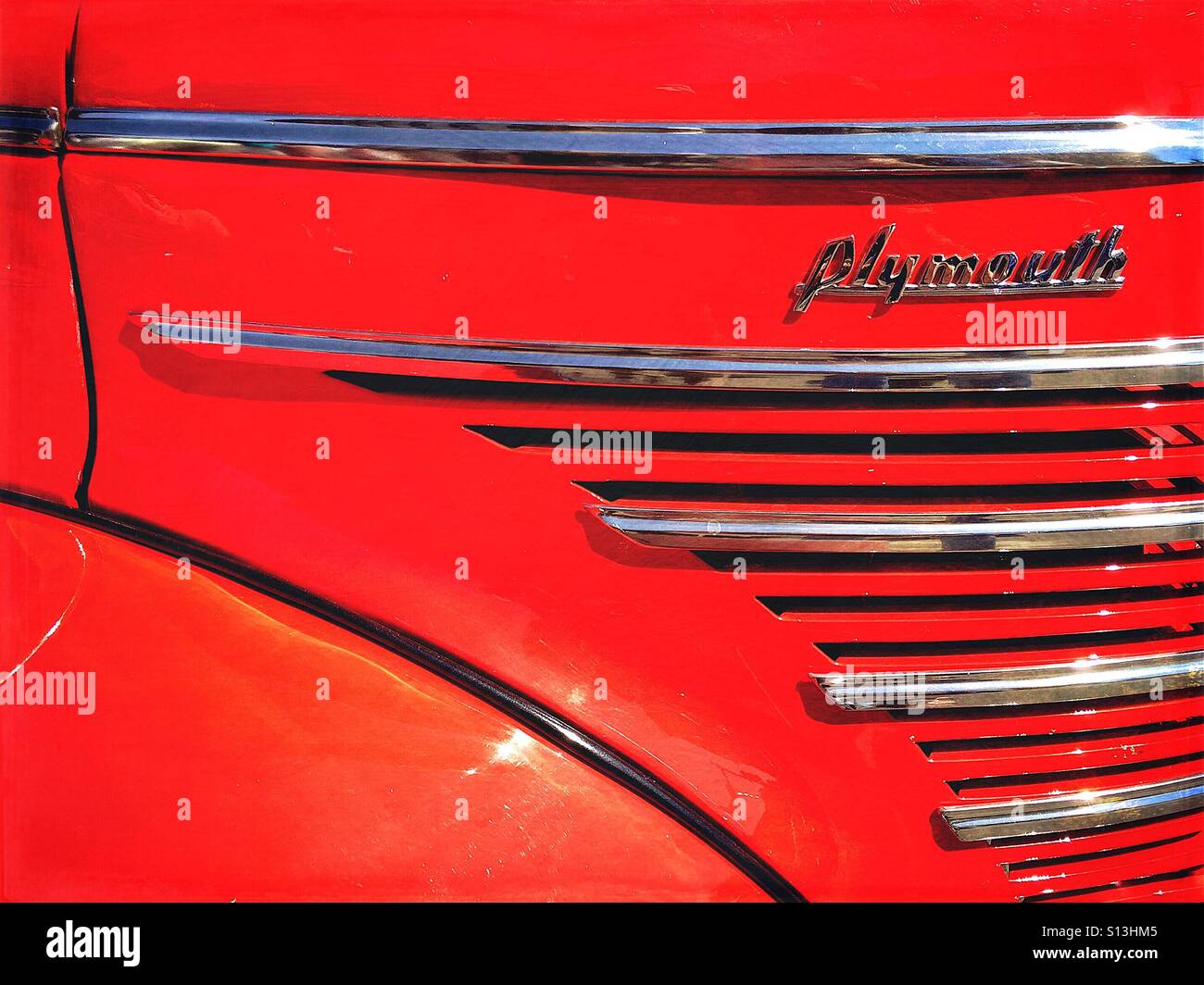 Dettaglio astratta della griglia e del parafango laterale di colore rosso brillante classic vintage Pontiac prese a classic car show a Bozeman, Montana, USA. Foto Stock