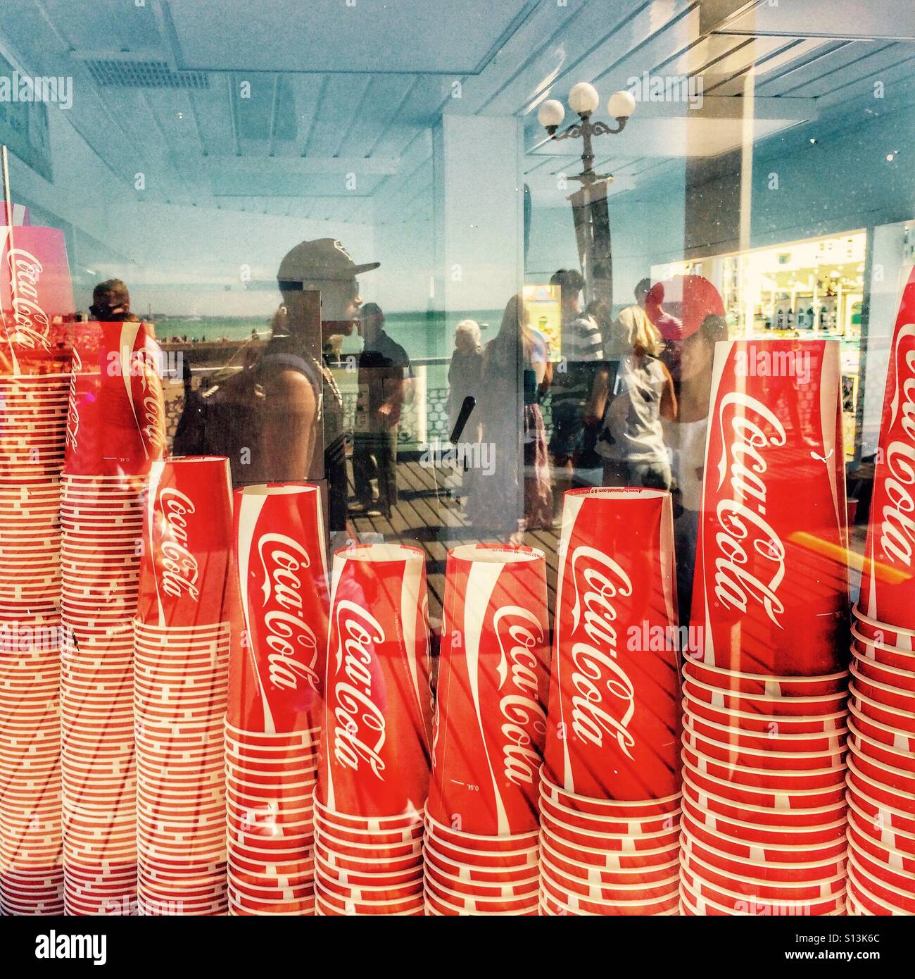 Coca Cola bicchieri impilati in una finestra sul molo di Brighton Inghilterra REGNO UNITO - Immagine stock catturata con smartphone