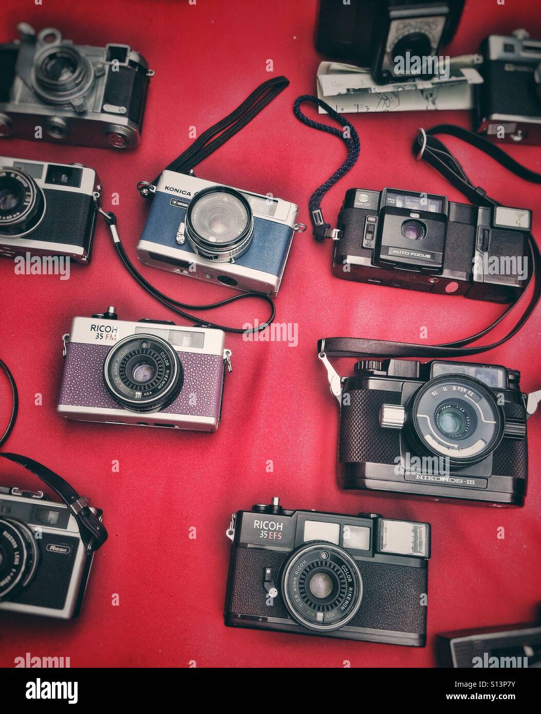Vecchia foto telecamere su un tessuto di colore rosso Foto Stock