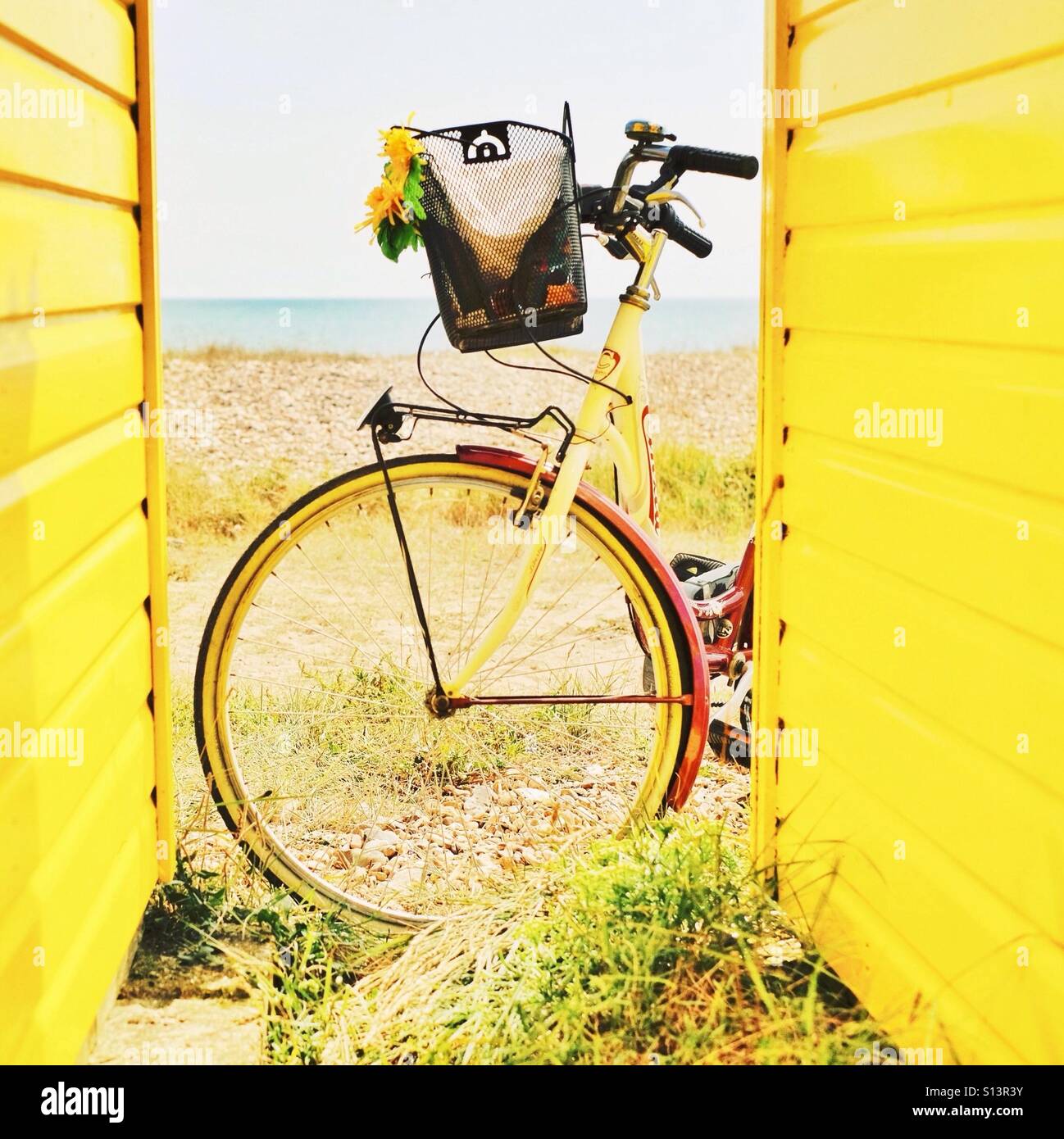 Un moto di colore giallo e la spiaggia di capanne in estate al mare Foto Stock