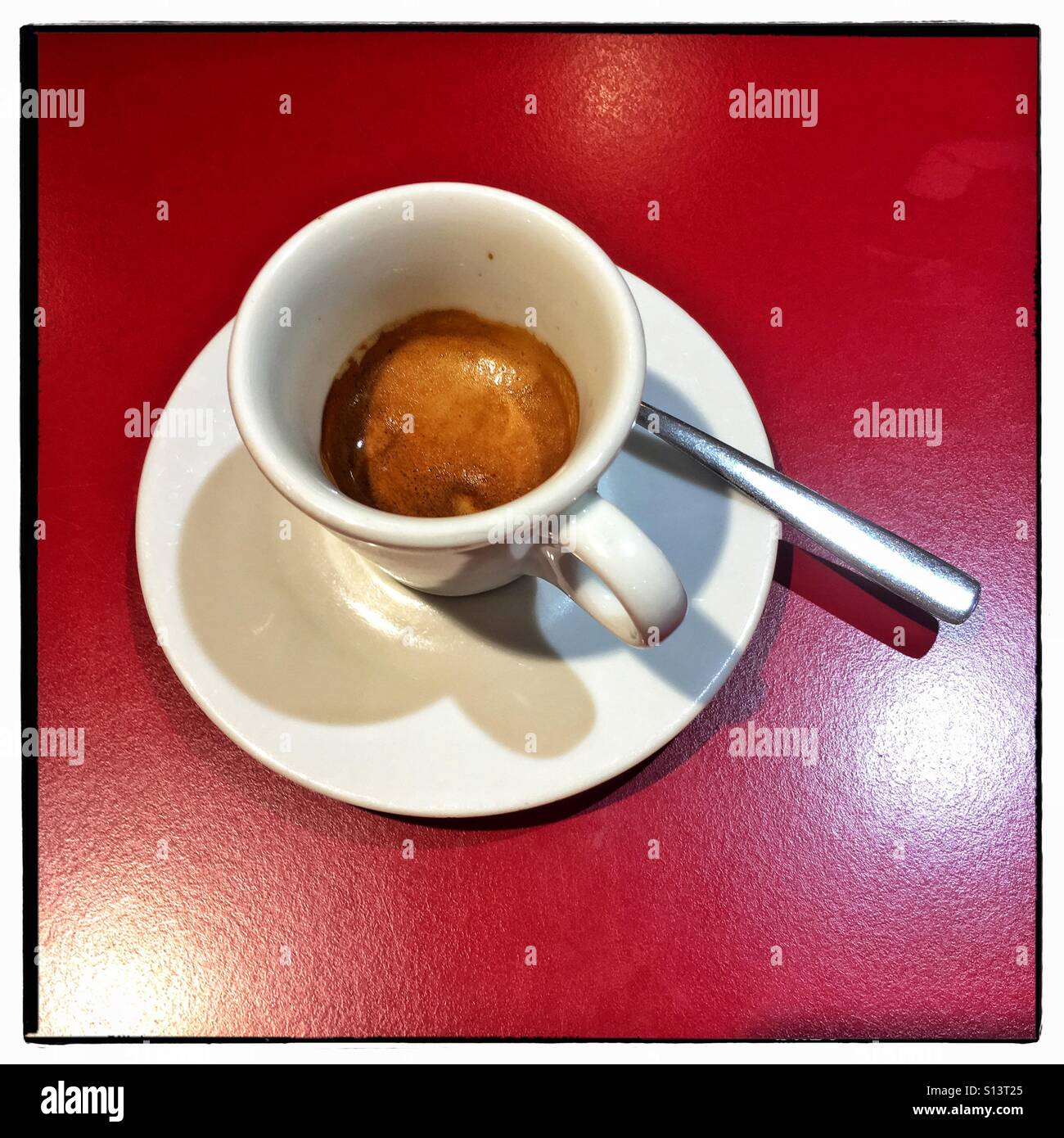 Caffè espresso in tazzina con piattino sulla tabella rossa Foto Stock