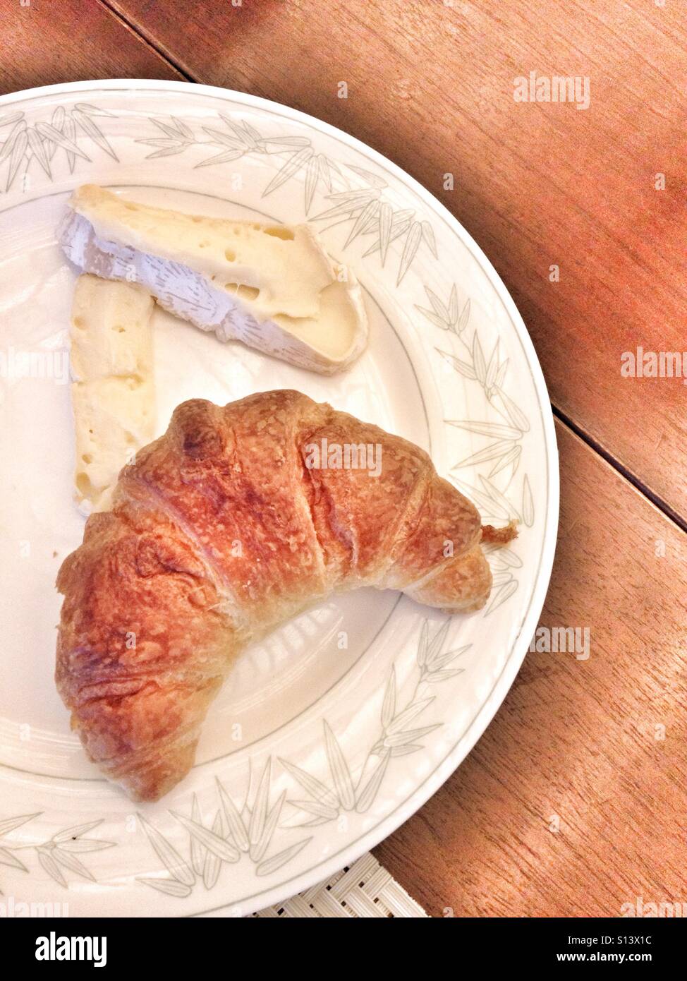 La deliziosa prima colazione Croissant sulla piastra bianca con Formaggio Brie sulla cima di un tavolo di legno Foto Stock
