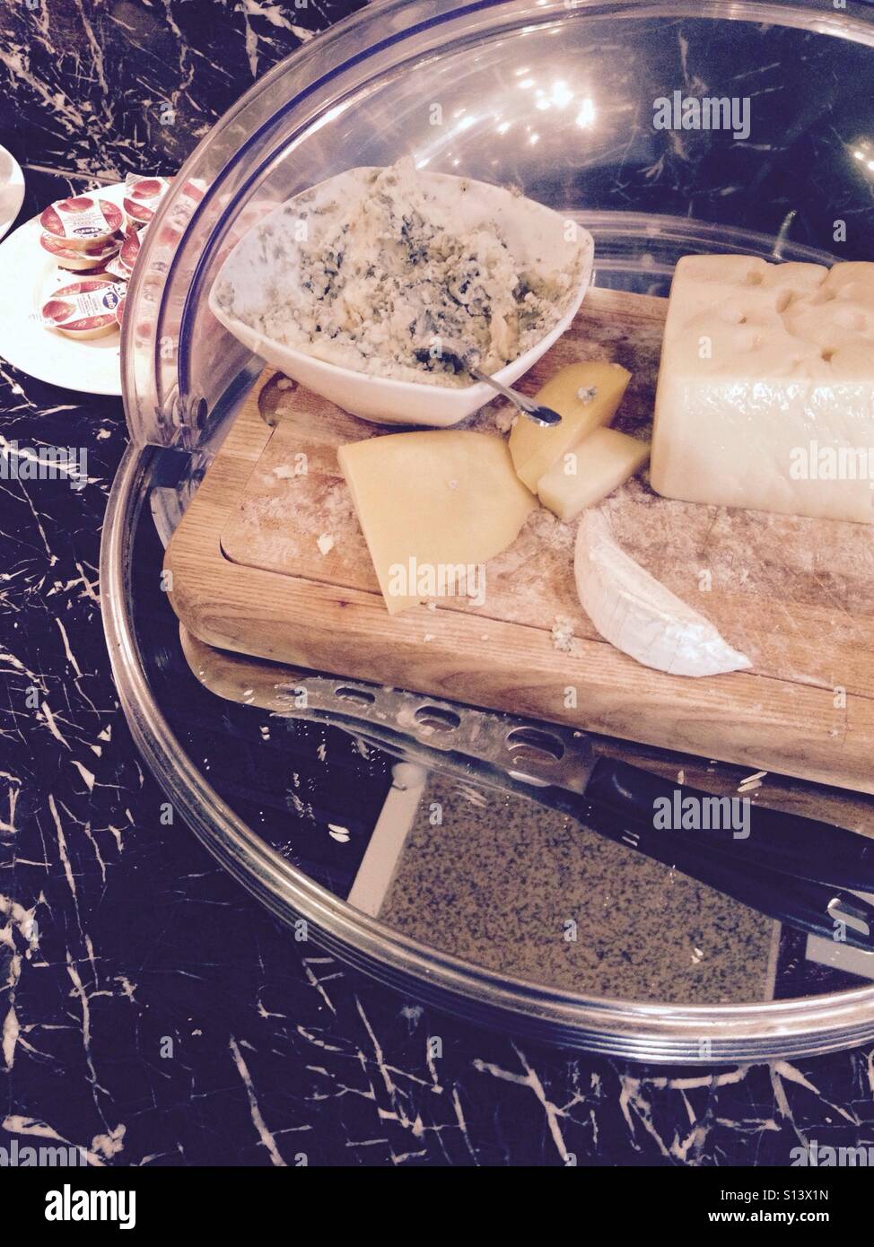 Quattro Formaggi a Buffet tavola di marmo con Brie, il formaggio svizzero, Cheddar, coltello Foto Stock