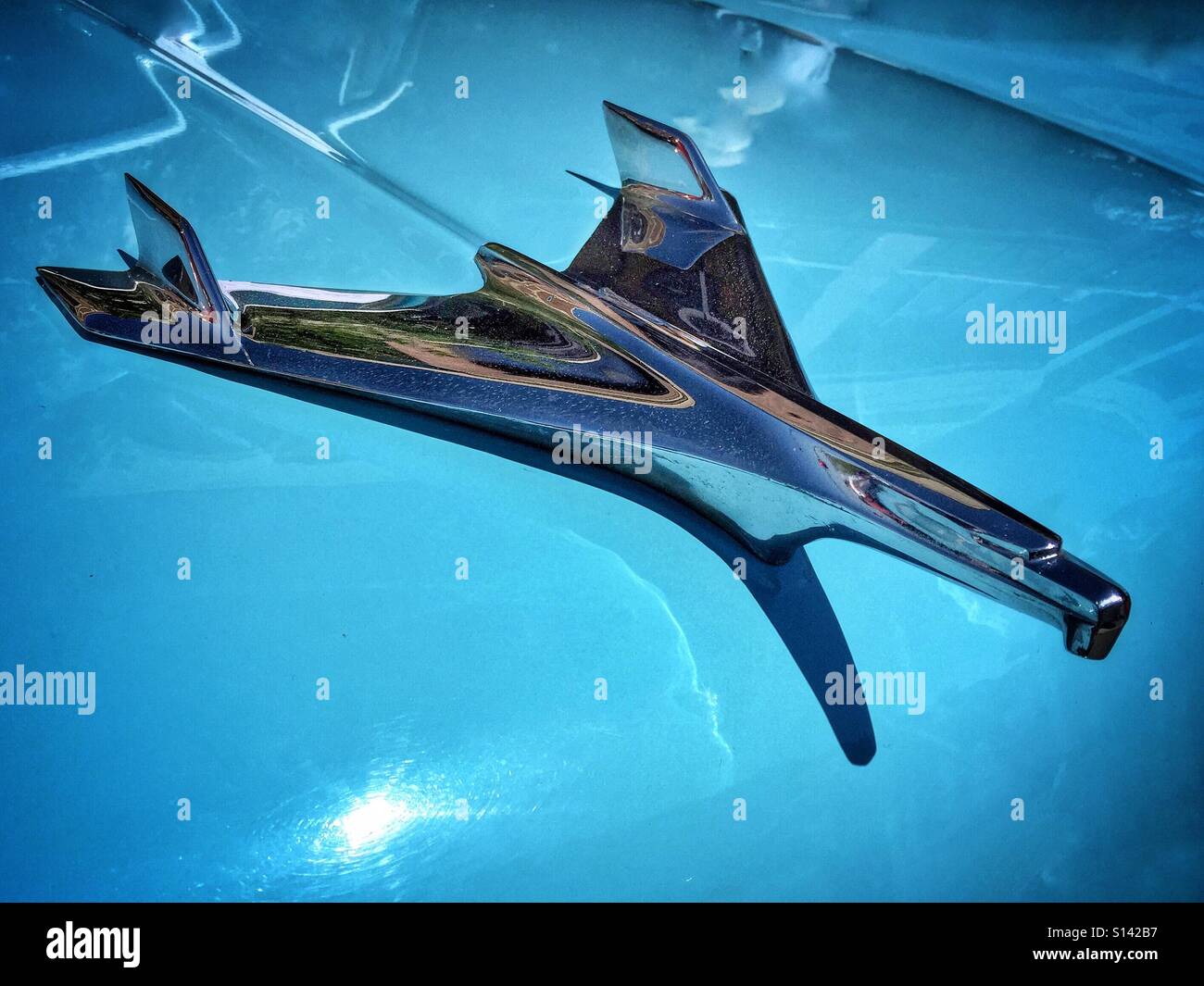 Chiudere dettaglio della cappa vintage ornamento noto come la Chevy Bird sul cofano cofano del classico auto blu. - Immagine stock catturata con smartphone