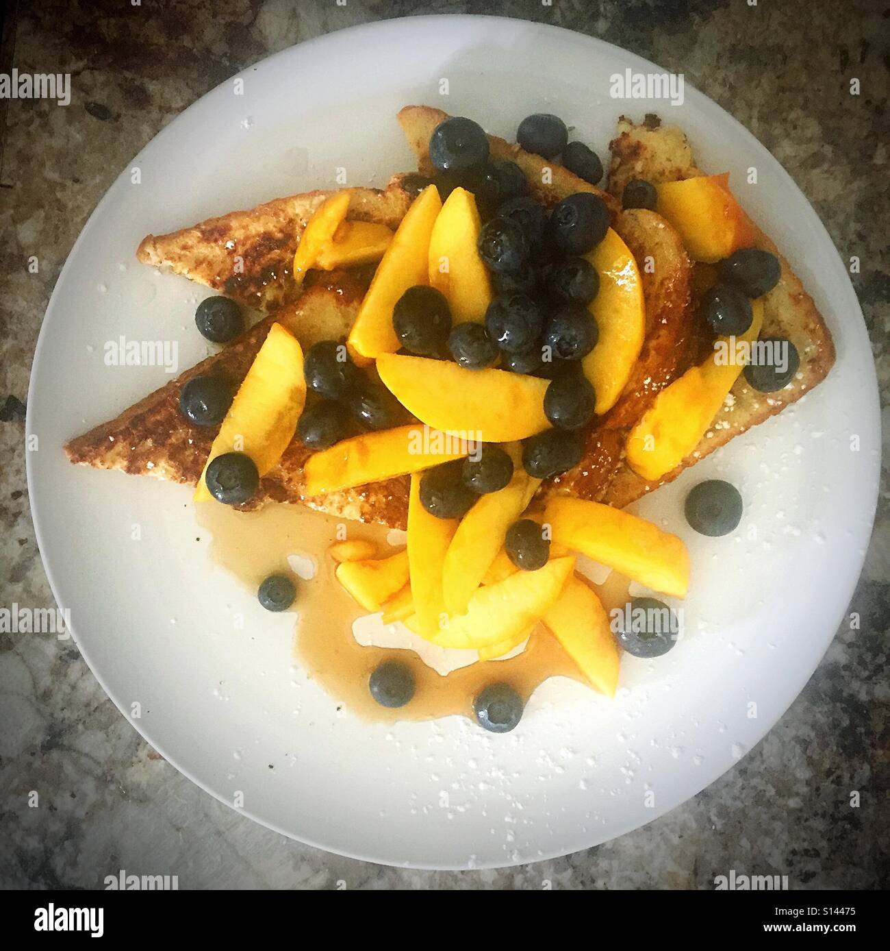Piastra del french toast ricoperto con lo sciroppo di pesche fresche e mirtilli. Fotografato dal di sopra. - Immagine stock catturata con smartphone