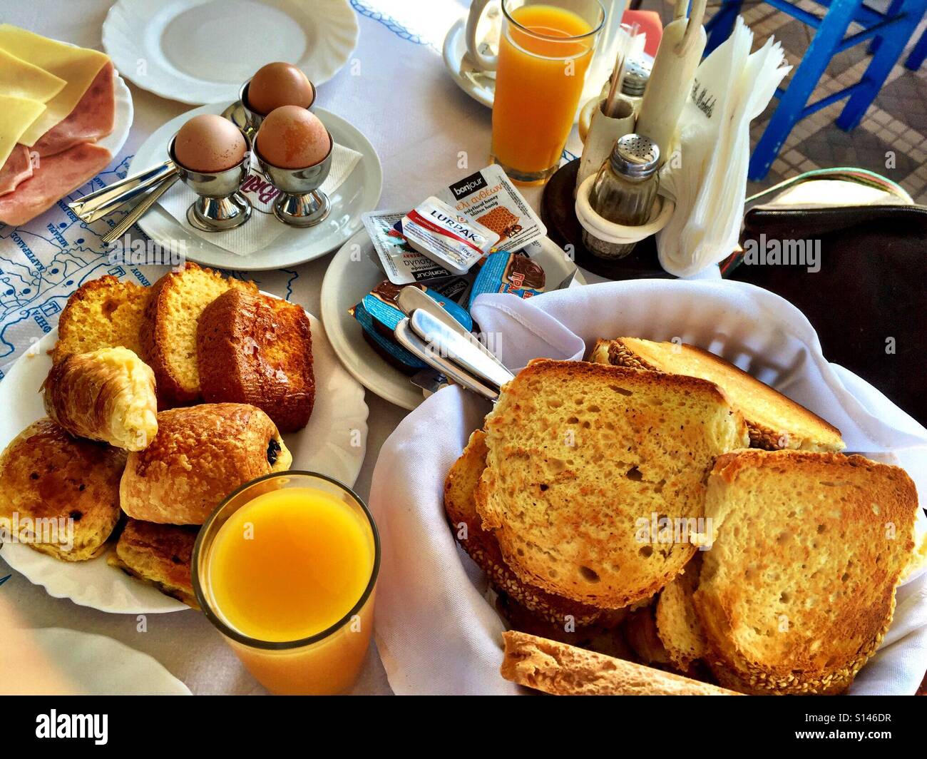 Un hotel Prima colazione con uova, toast, pasticcini e succo di frutta fresco. Foto Stock