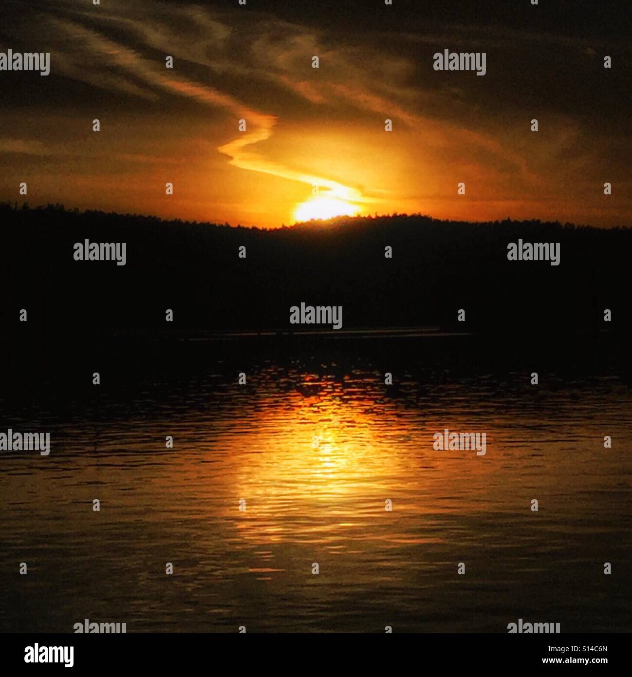 Impostazione di Golden Sun con un insolito cloudscape e golden riflessione. Foto Stock