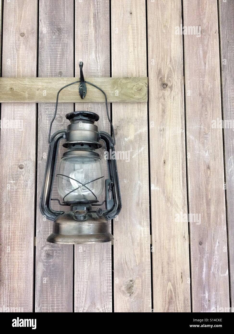 Vecchio Vintage del contadino Lampada Lanterna appesa su assi di legno di legno sfondo a parete Foto Stock