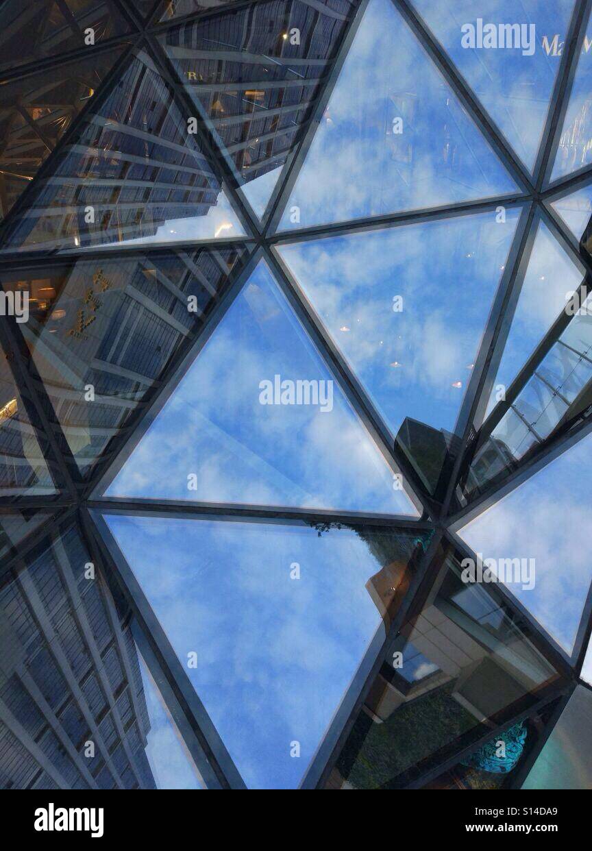 I triangoli di vetro riflette il cielo blu chiaro Foto Stock