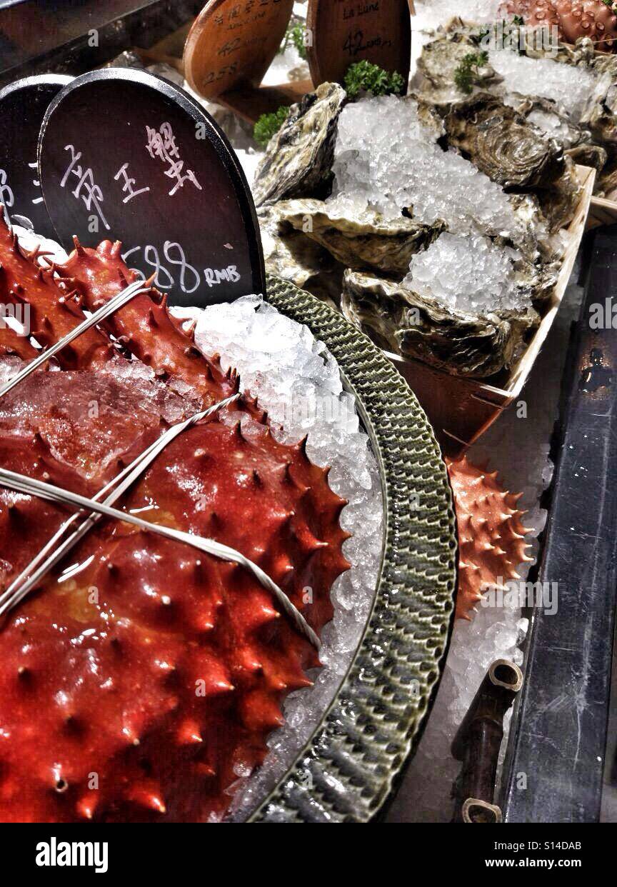 Frutti di mare ghiacciato a un mercato del pesce, tra cui il re granchi e vongole veraci Foto Stock