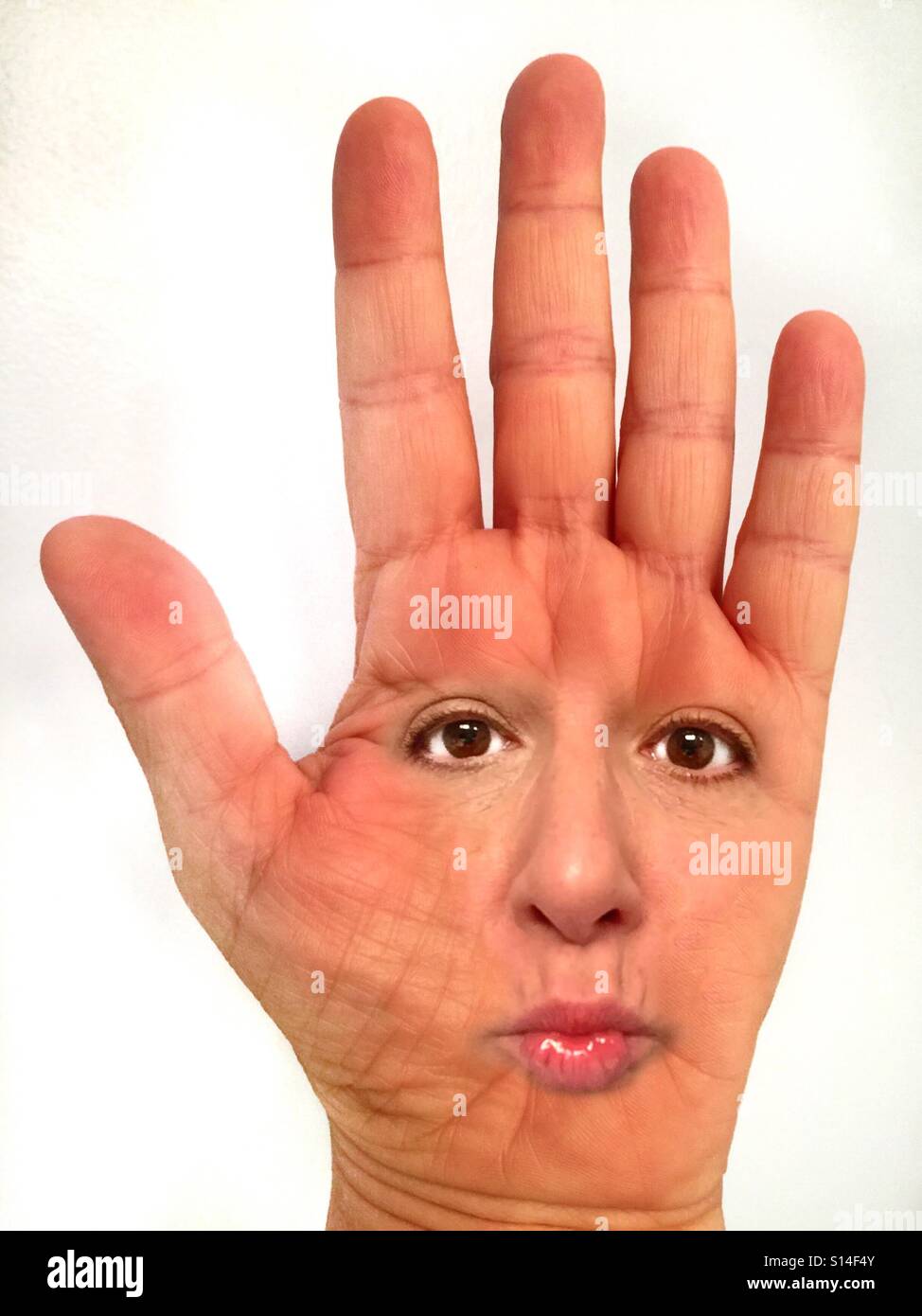 Un immagine astratta di un volto di donna sul palmo di una mano. Foto Stock