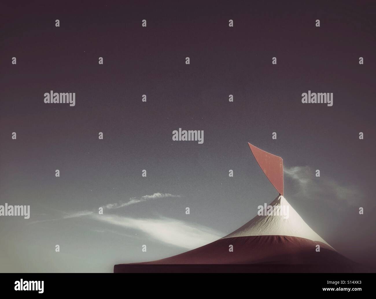 Una bandiera sulla cima di un rosso e bianco la tettoia si staglia contro un cielo chiaro. - Immagine stock catturata con smartphone