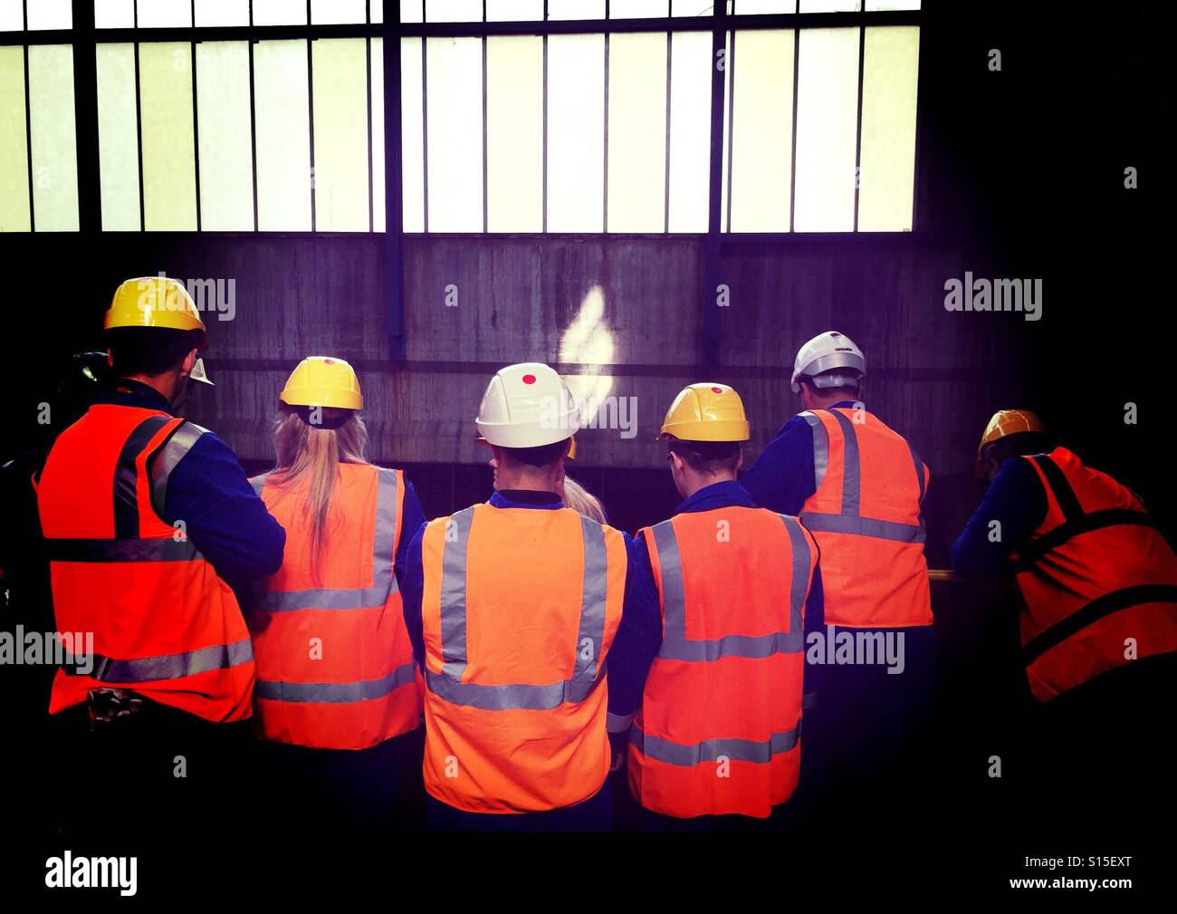 Lavoratori in hi-viz abbigliamento protettivo e giacche nel luogo di lavoro industriale Foto Stock