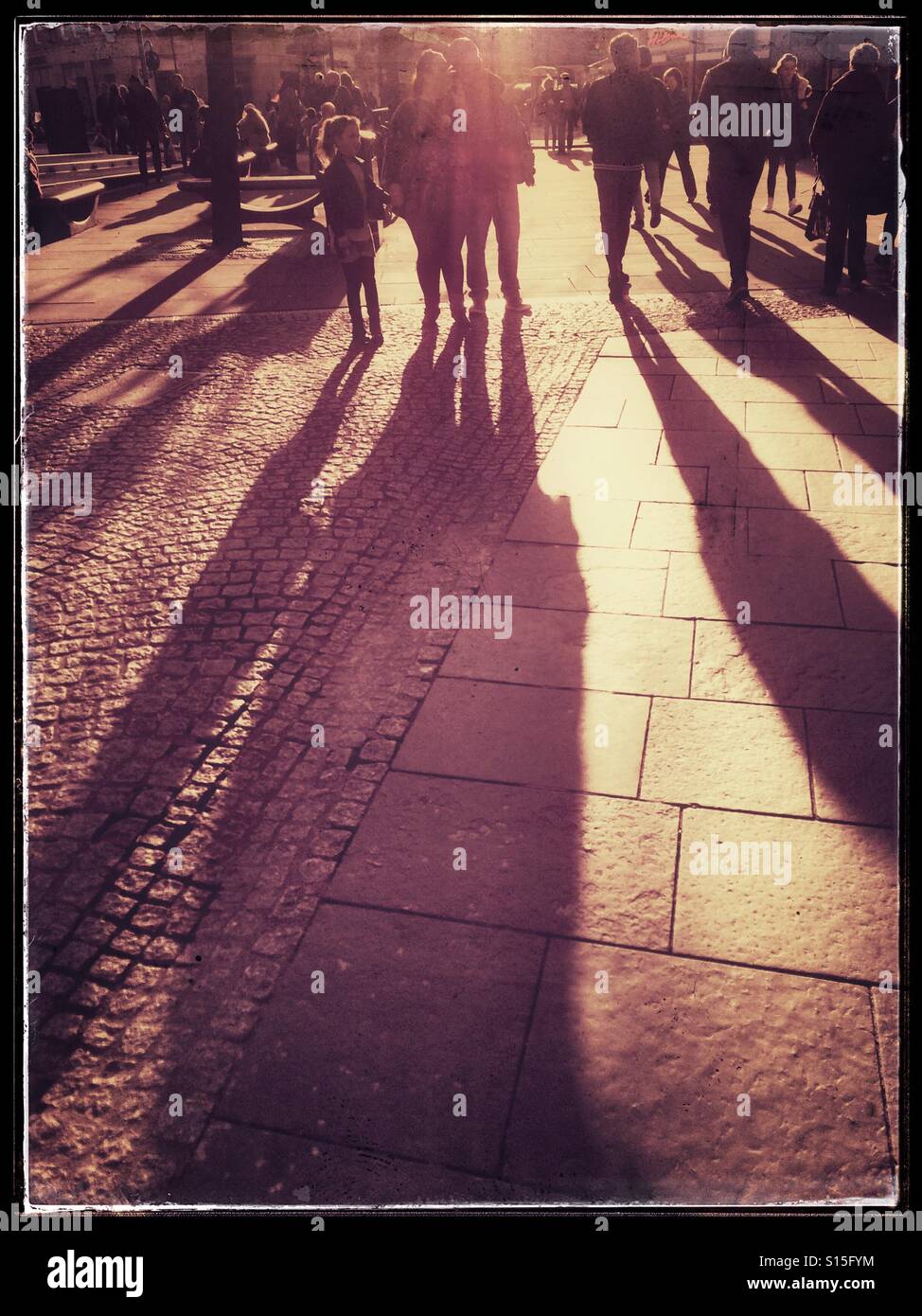 La strada affollata con bassa sole e ombre lunghe Foto Stock