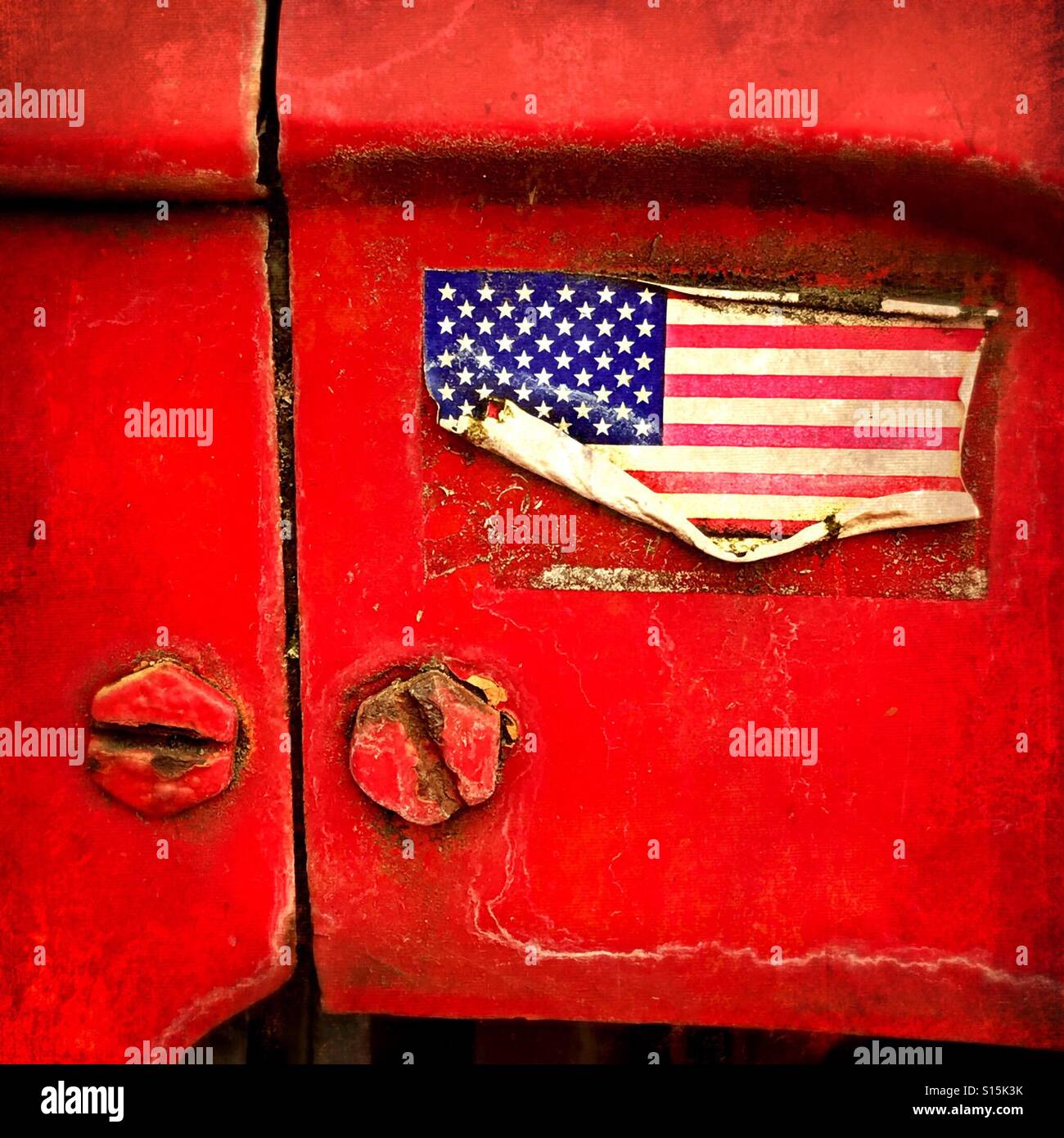 Un vecchio weathered bandiera americana adesivo su un trattore agricolo. Americana! Foto Stock
