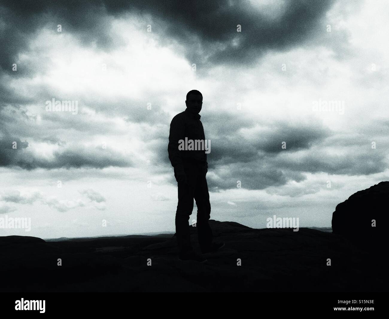 Silhouette uomo sulla cima della montagna - bianco e nero - Immagine stock catturata con smartphone