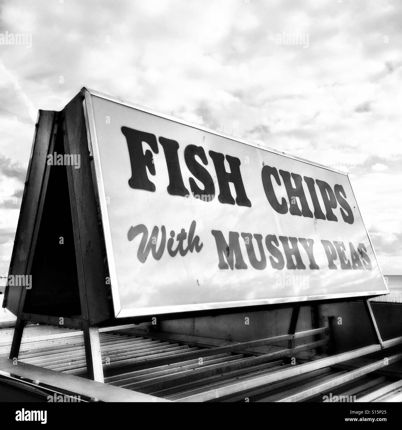 British lungomare fast food segno "pesce con patatine fiacco piselli" in bianco e nero, Brighton, Inghilterra Foto Stock