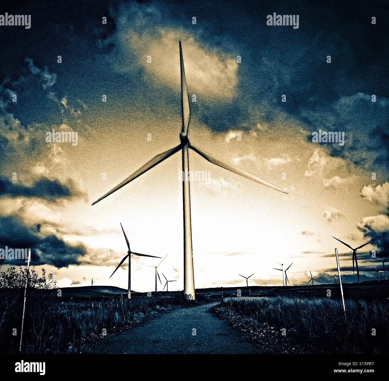 Turbine eoliche che utilizzano energia eolica sotto il cielo spettacolare, Scozia - Immagine stock catturata con smartphone