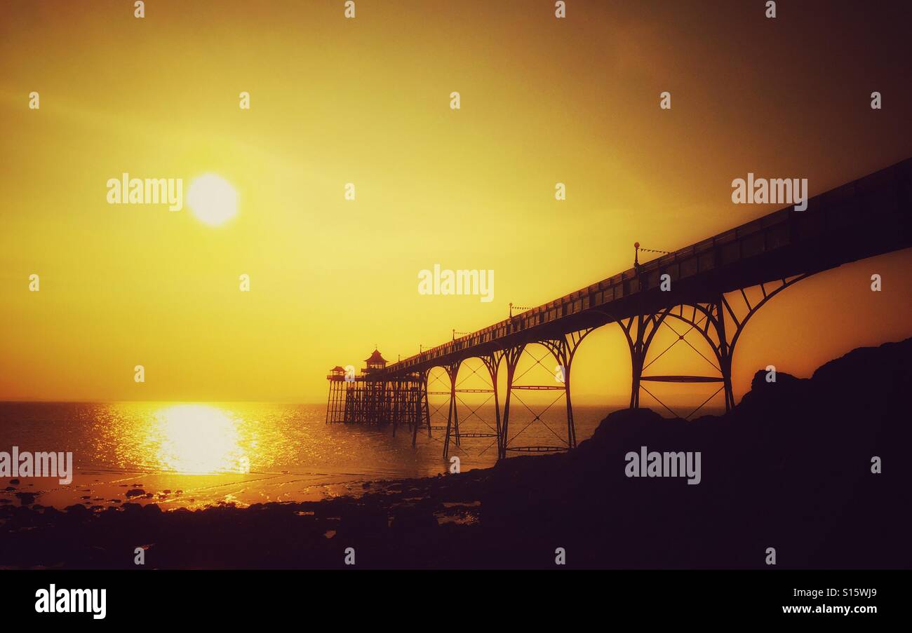 Una vista ovest, verso il Galles, di Clevedon Pier come il sole comincia a impostare. Clevedon Pier è un grado uno struttura elencate ed è stato costruito nel corso del periodo vittoriano. Credito foto - © COLIN HOSKINS. - Immagine stock catturata con smartphone