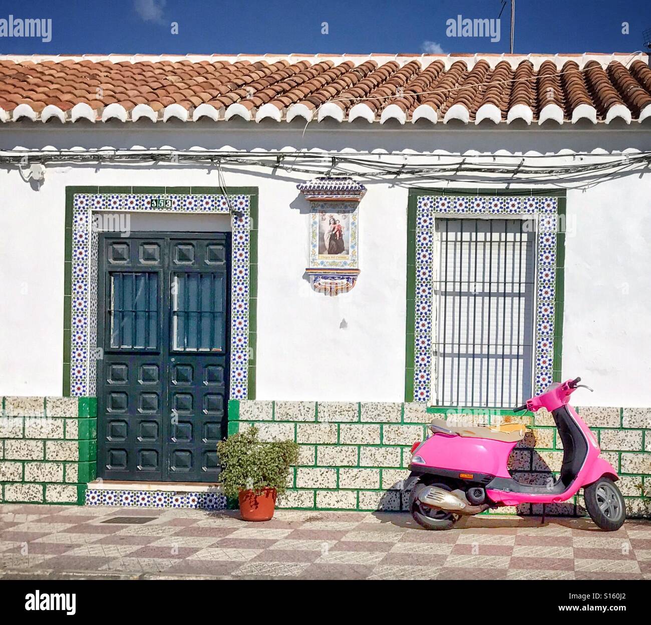 Una rosa Vespa scooter parcheggiato al di fuori di un tradizionale Fisherman's cottage in Caleta de Vélez, nei pressi di Malaga, Spagna Foto Stock