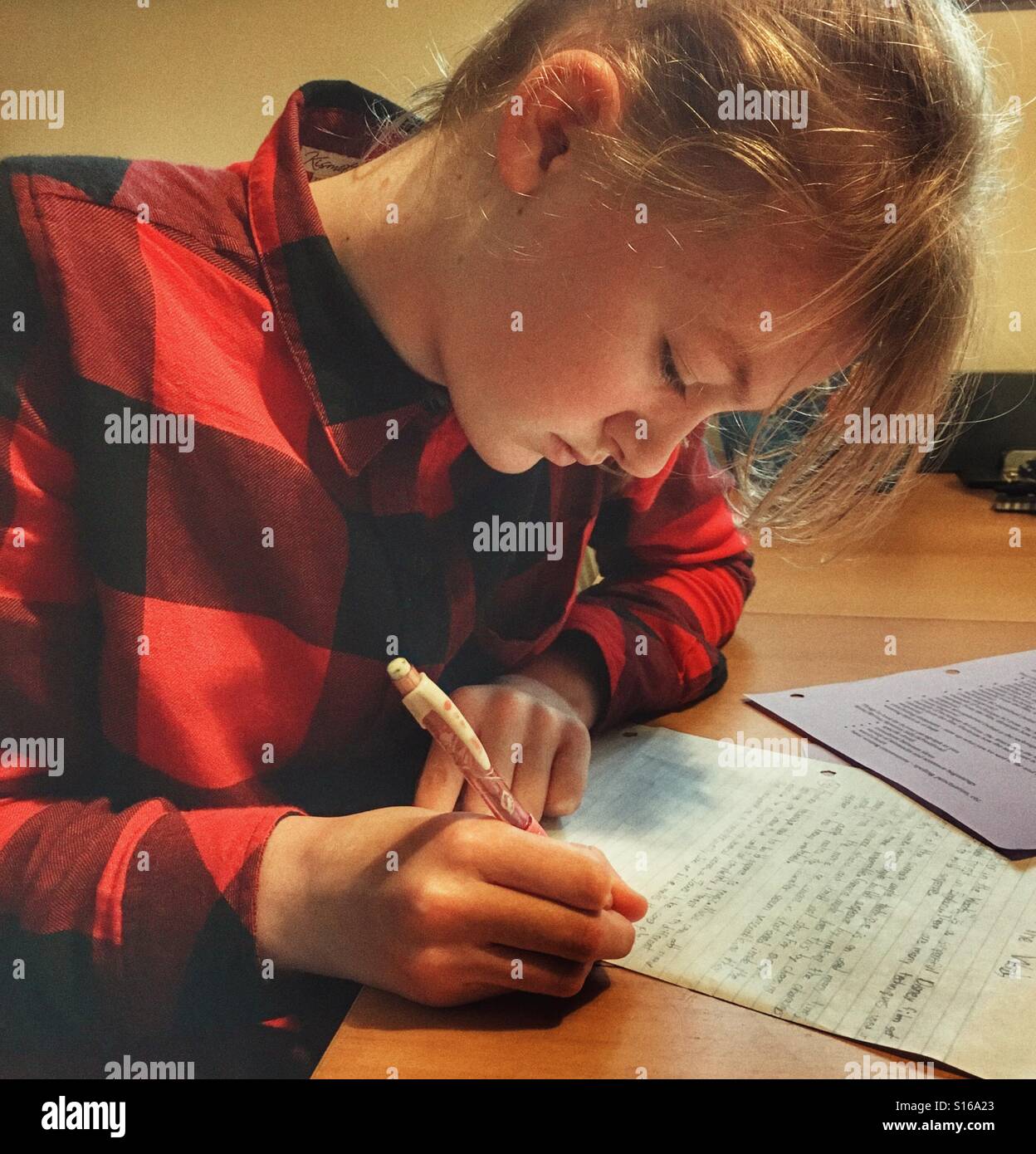 Ragazza adolescente studiare al tavolo della cucina Foto Stock