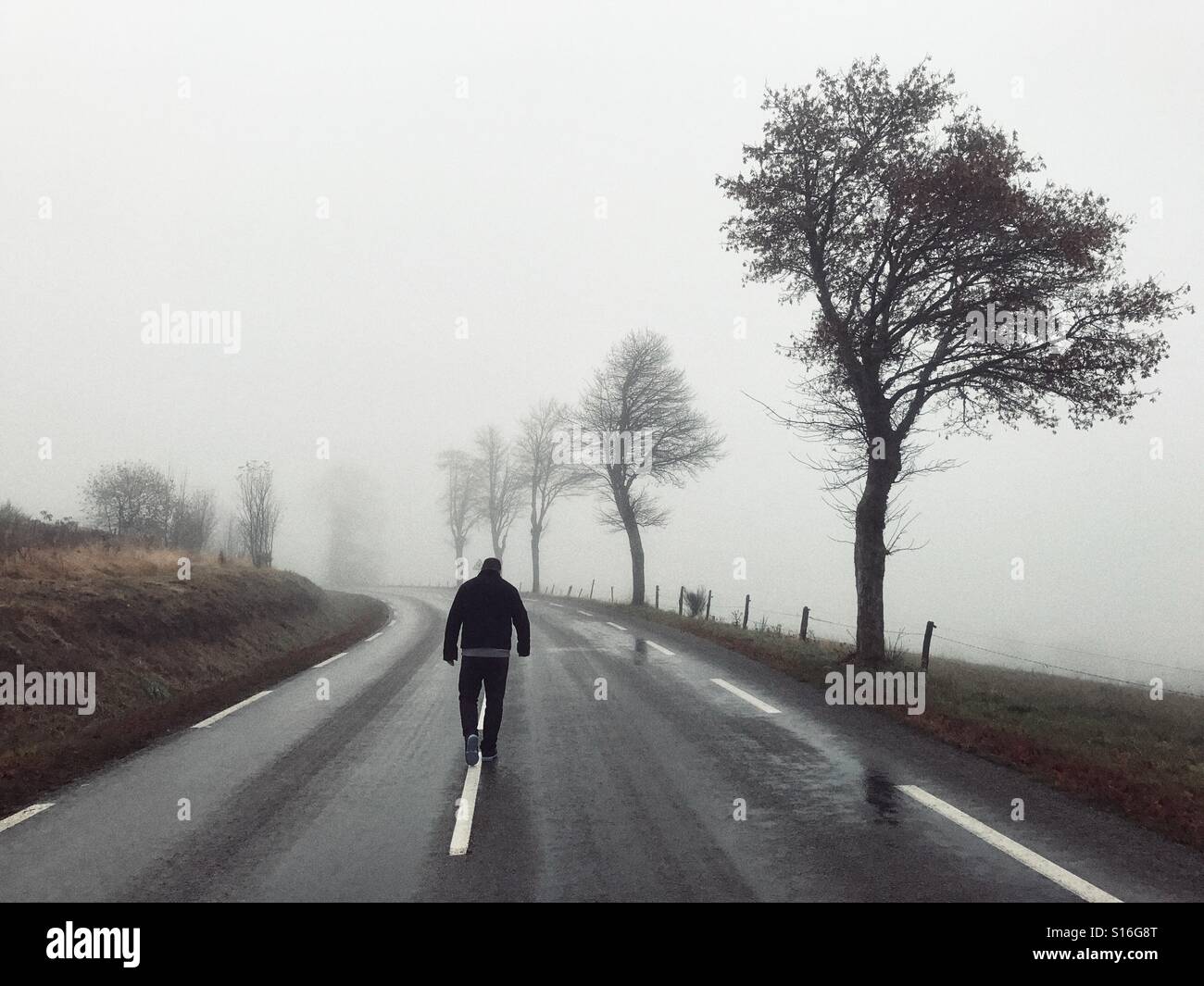 Uomo che cammina in mezzo alla strada Foto Stock