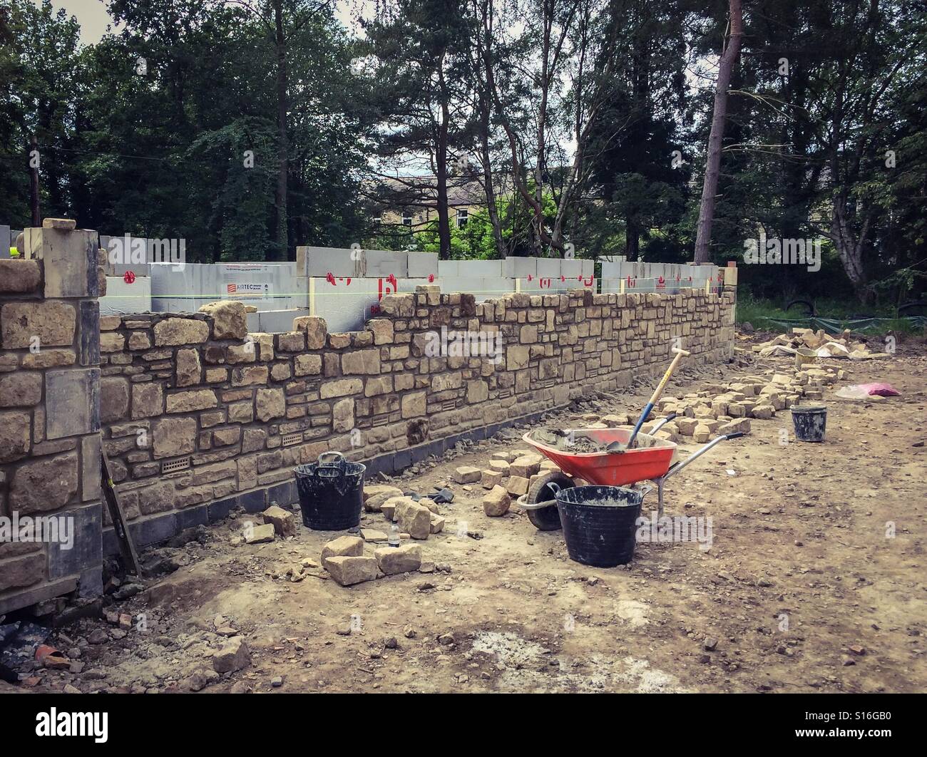 Muro di pietra in costruzione su una nuova build del progetto di costruzione - Immagine stock catturata con smartphone