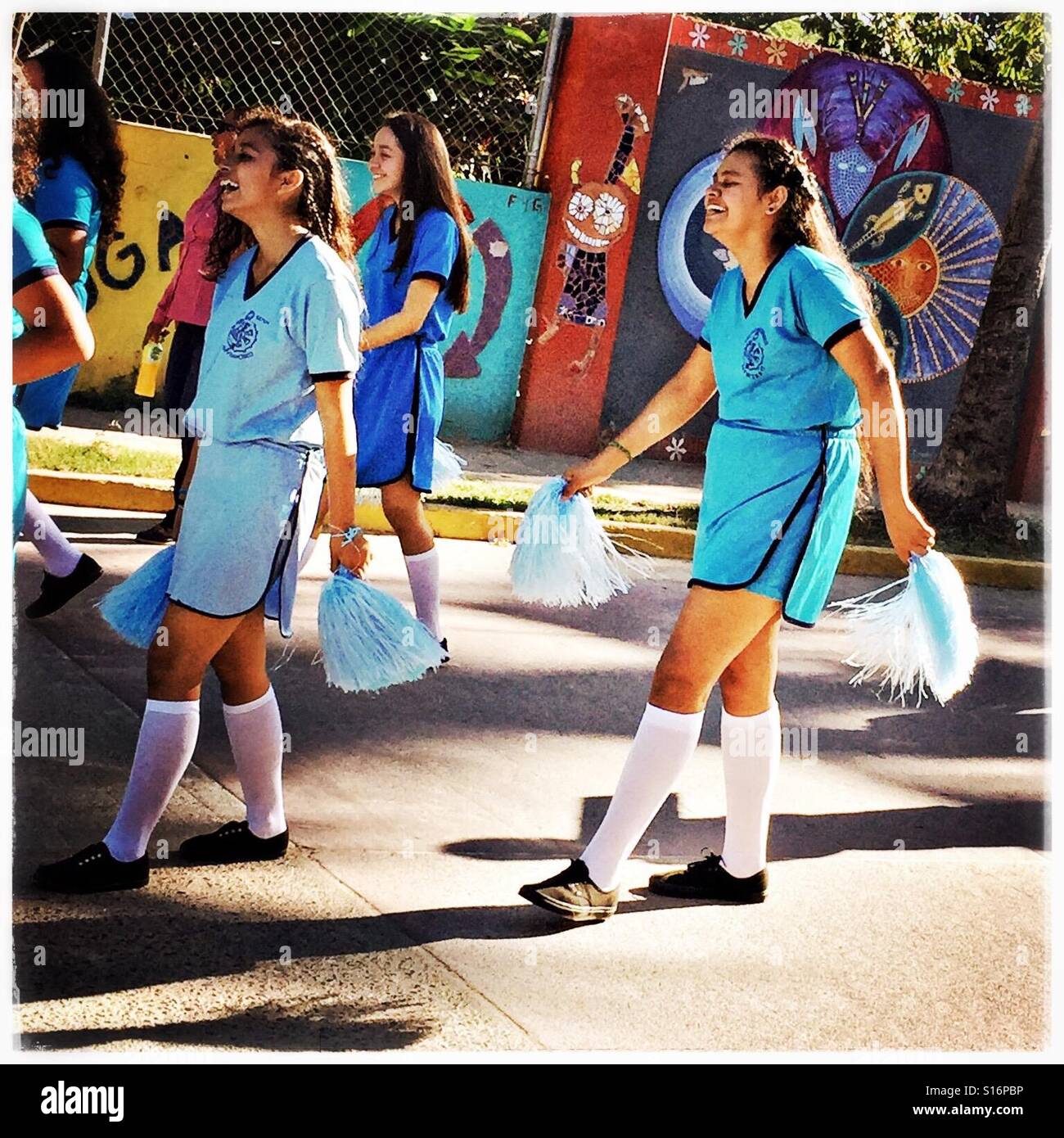 Le ragazze di condividere un momento di spontanea risate come essi partecipano al Día de la Revolución sfilata il 20 novembre a San Pancho, Nayarit, Messico. Foto Stock