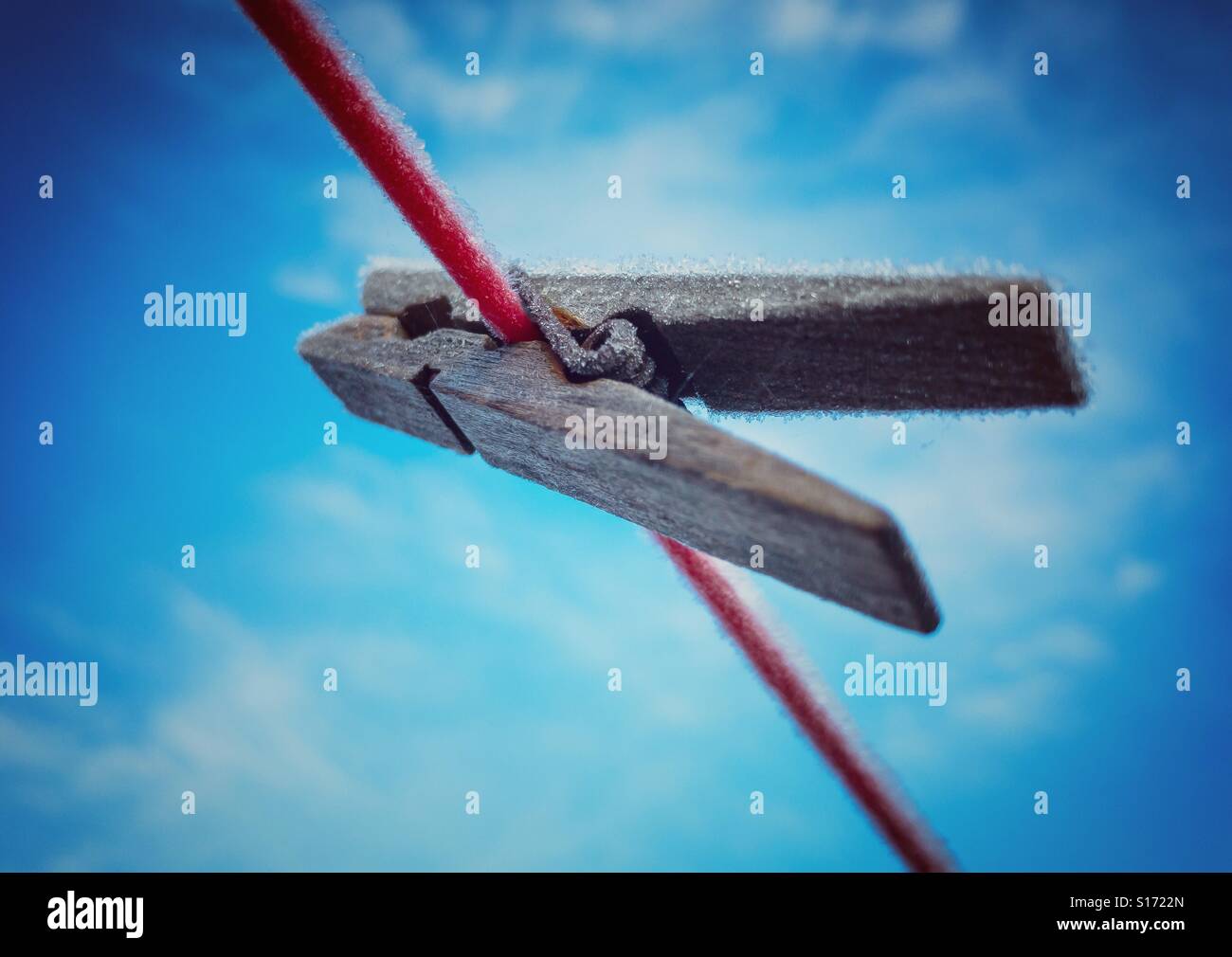 Coperto di brina abbigliamento peg sulla linea di lavaggio contro un cielo blu Foto Stock