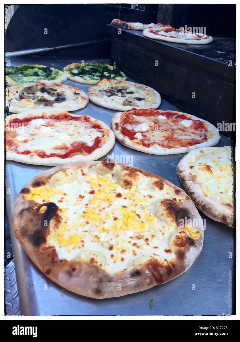 Pizza cotta torte fresche dal forno, USA, 2015, © Katharine Andriotis Foto Stock